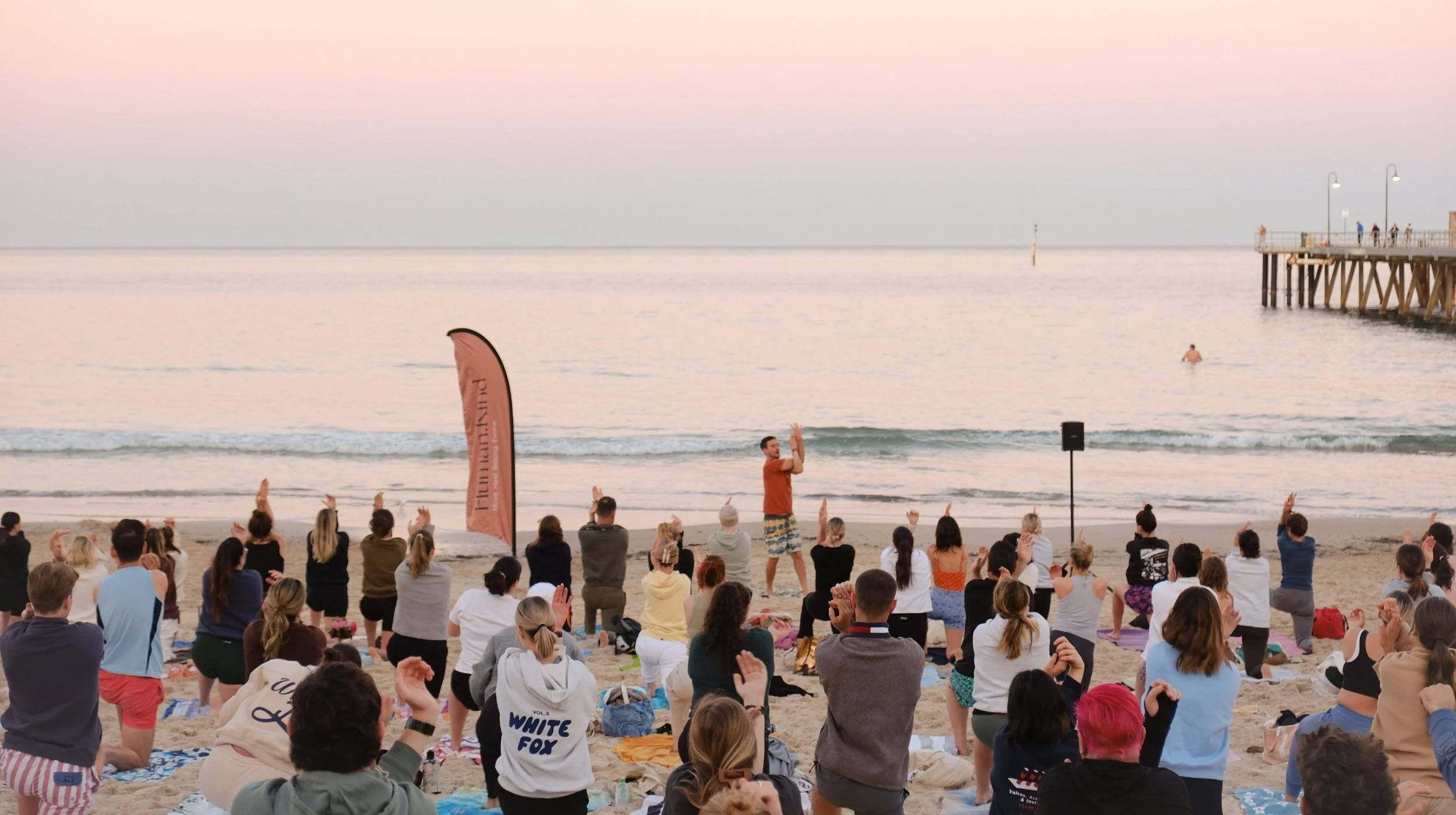 a man teaches yoga on the beach