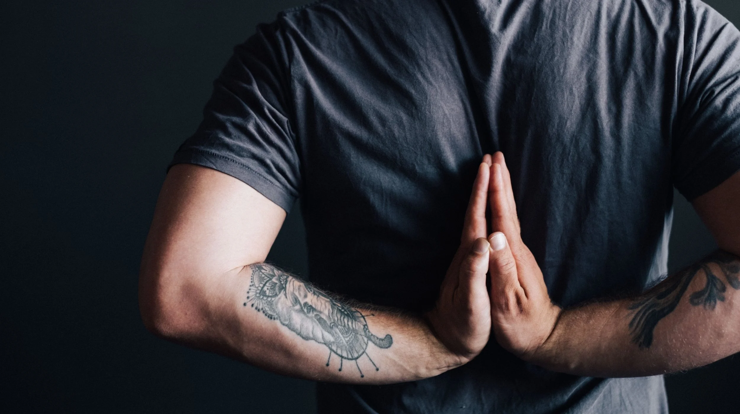 hands clasped behind a mans back in prayer