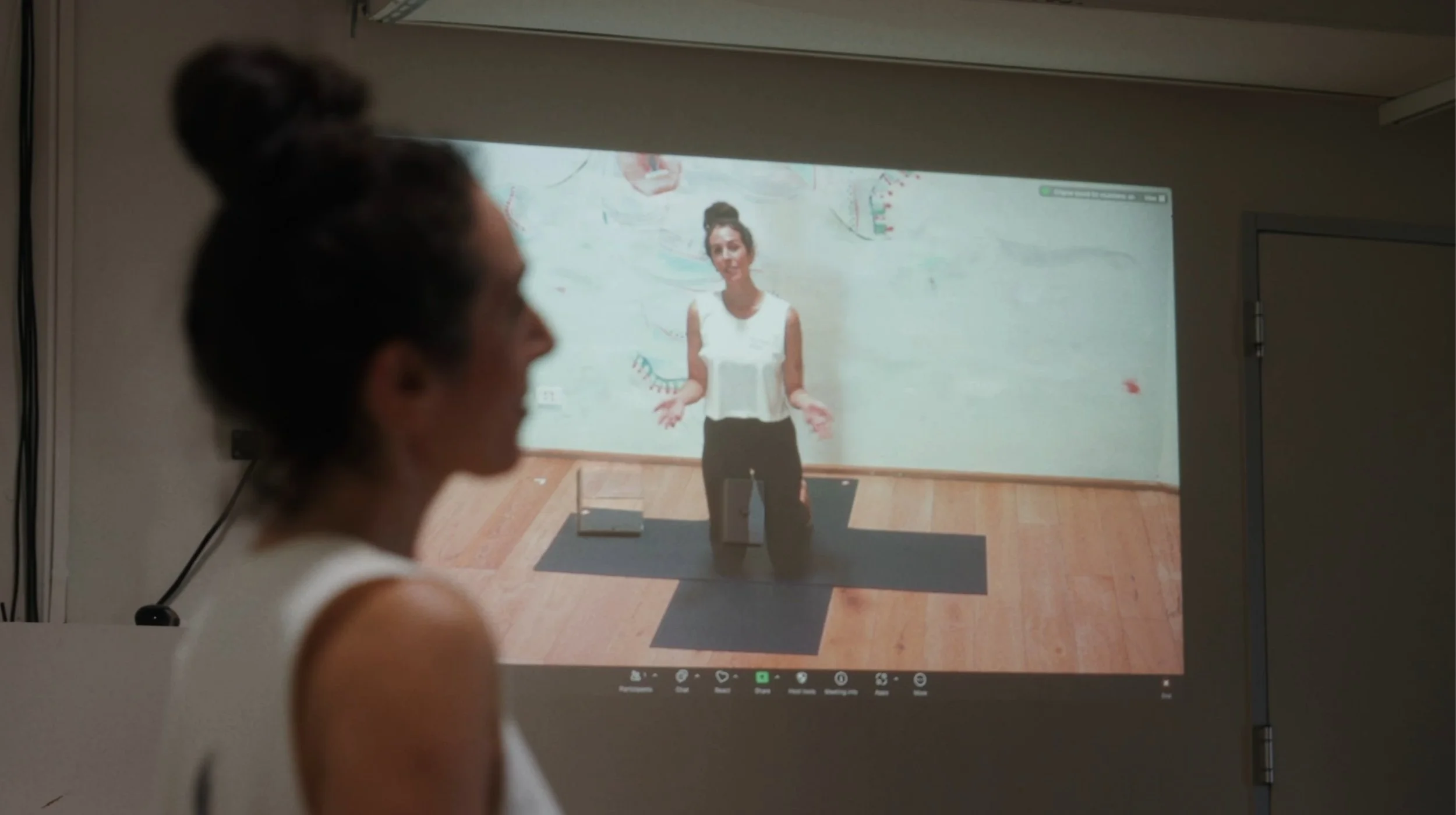 a projection of a yoga teacher on a wall