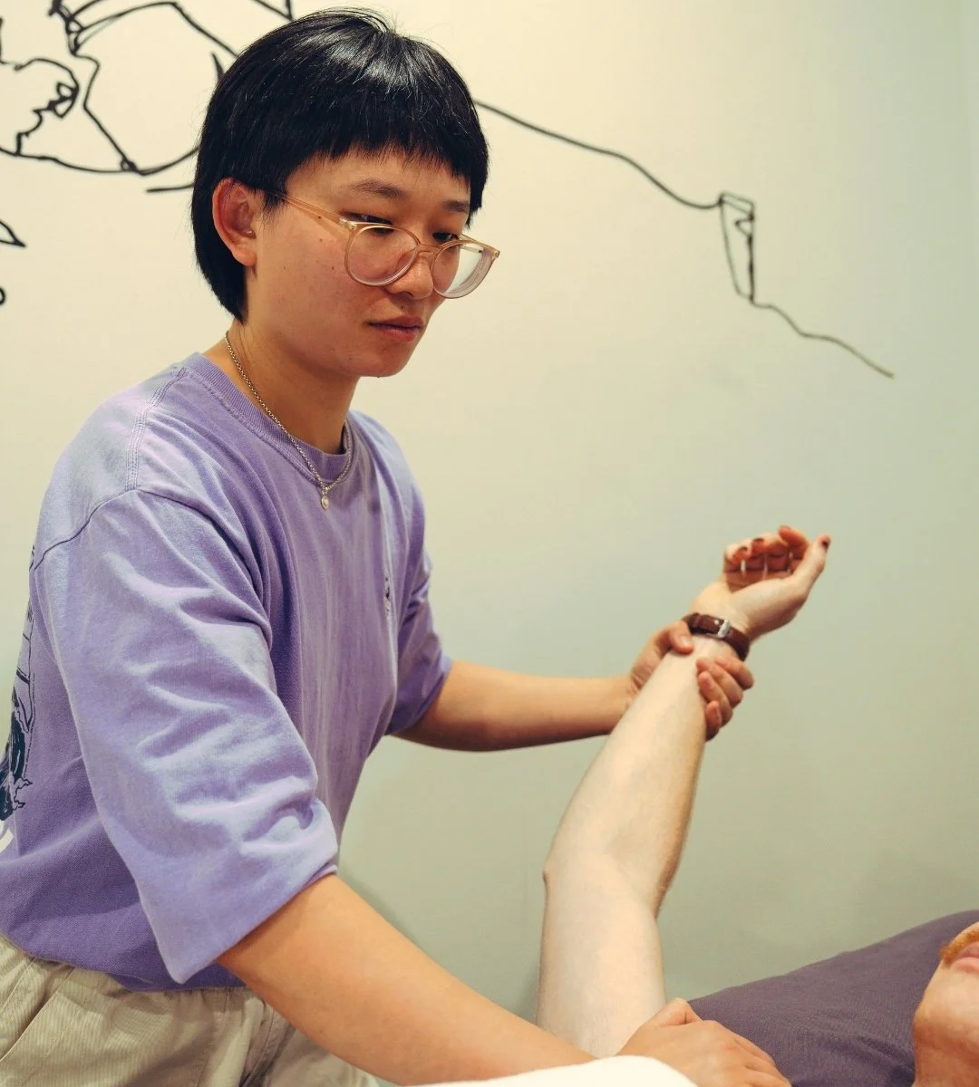 a massage therapist treats a client