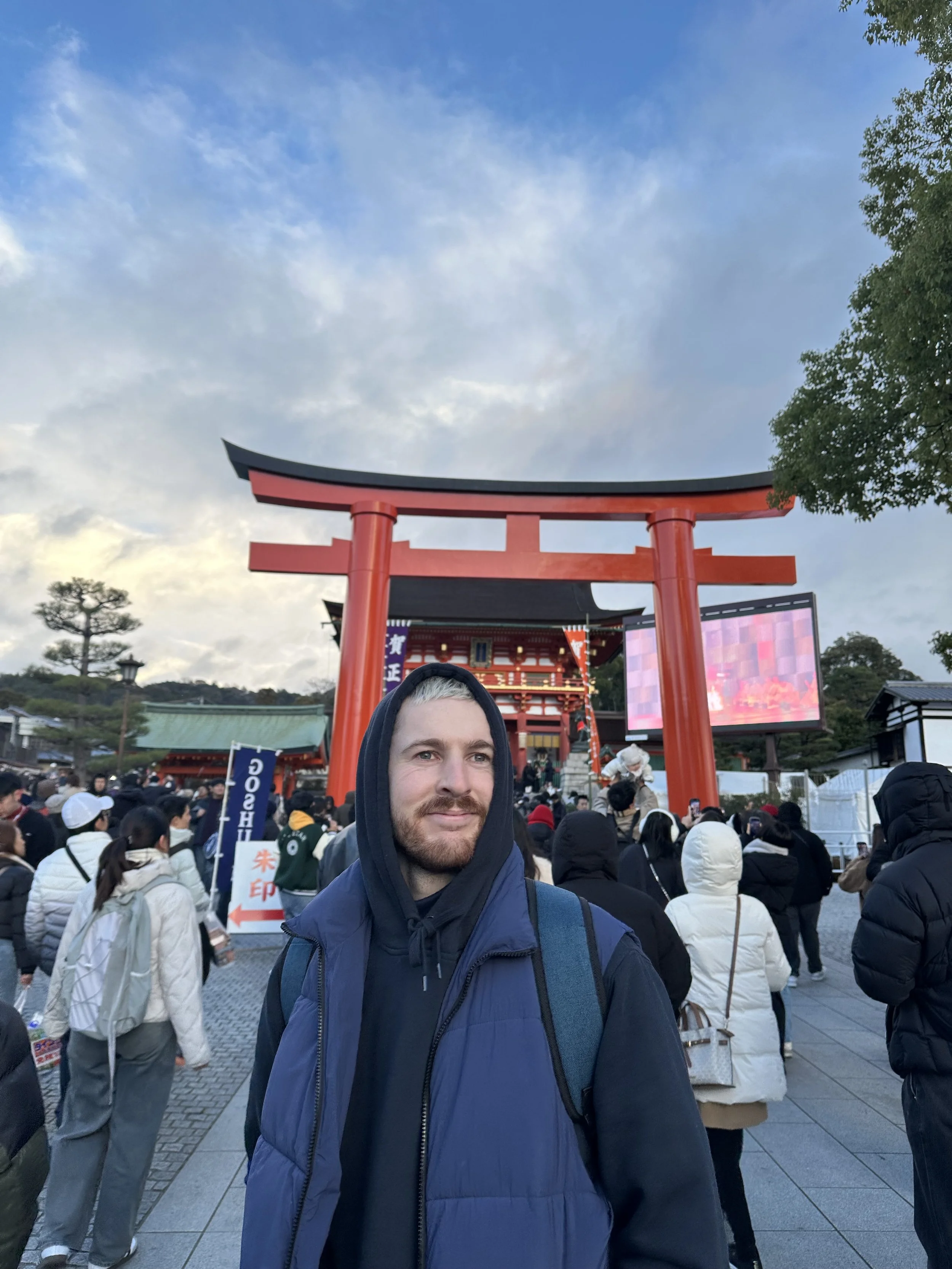 Detail Culture founder at Fushimi Inari Shrine in Kyoto, standing beneath the red torii gates that inspired the brand’s Japanese car culture influence.