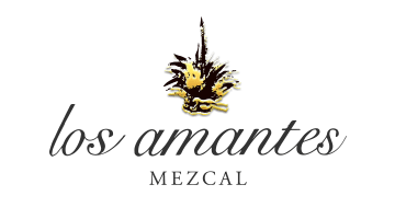 Logo de un mezcal llamado 'los amantes', con una ilustración de una figura con alas doradas y una copa en la mano