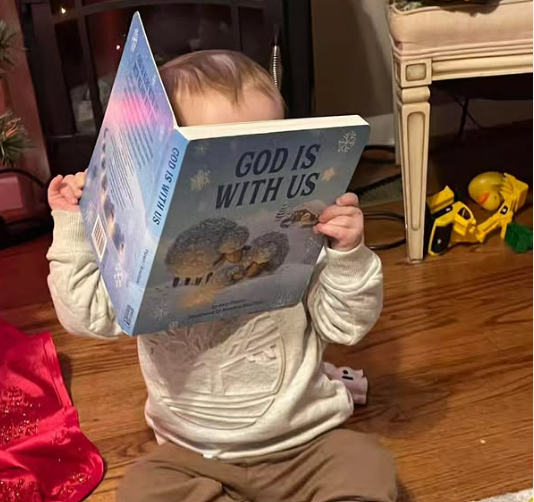 Baby reading God Is With Us