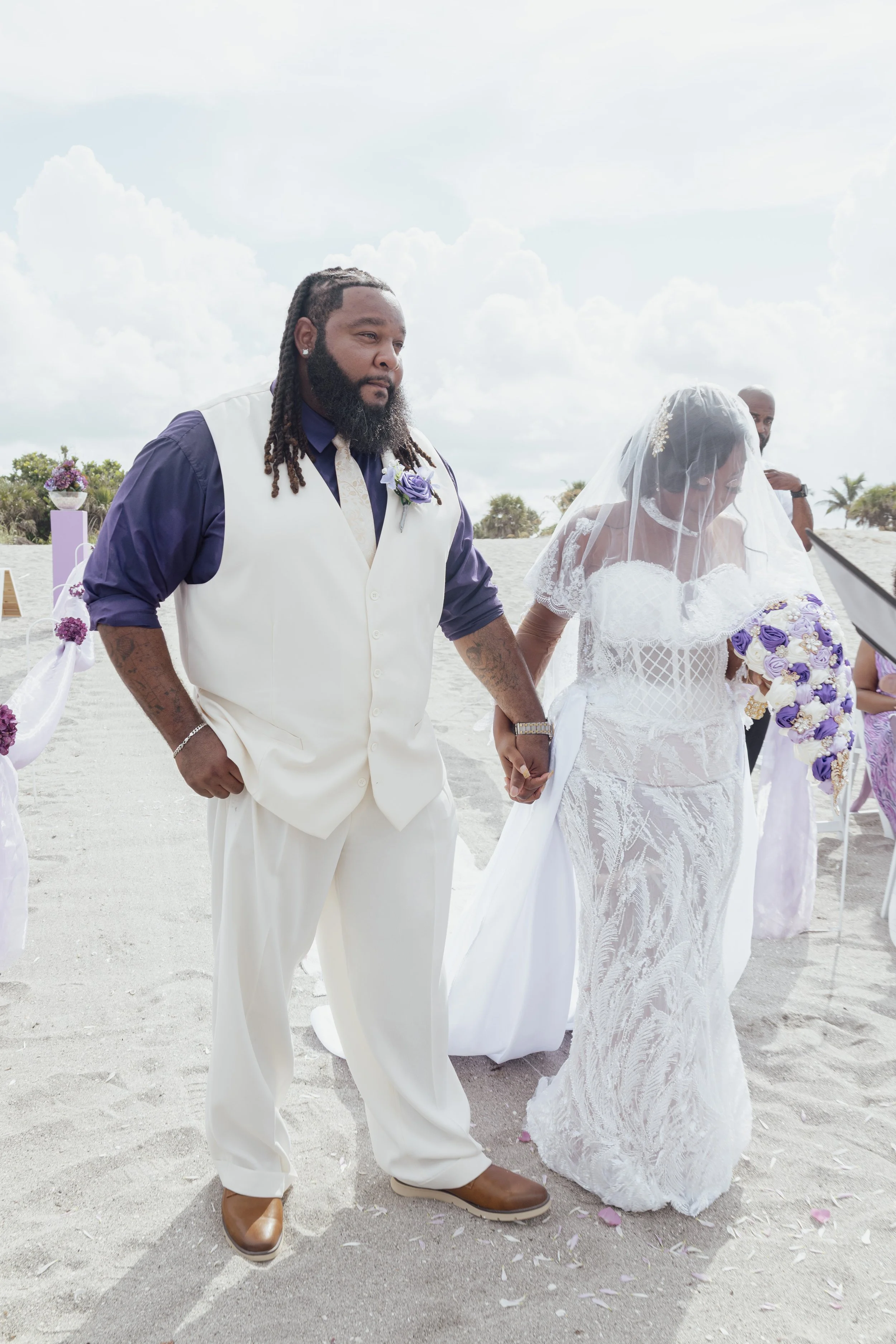 bride and groom walking down the beach