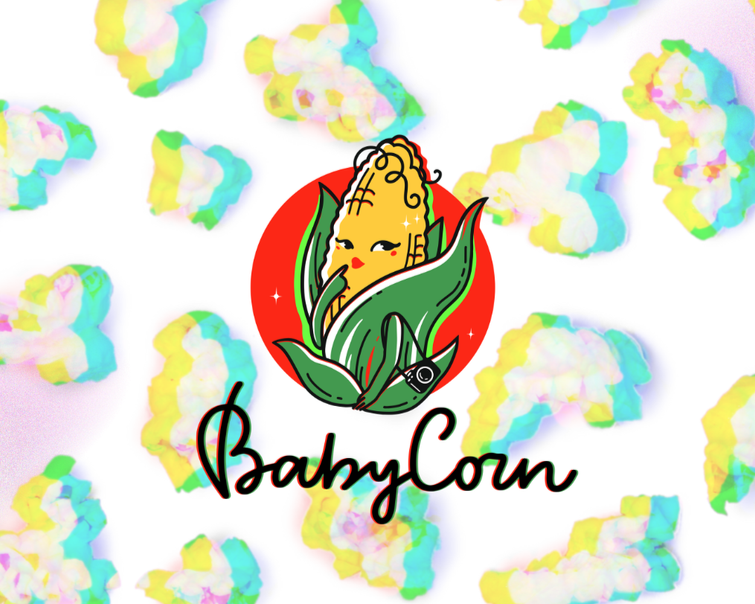 A playful logo for BabyCorn featuring a cartoon baby corn character with curly hair and red lips, sitting in a green corn husk with a small fish at its side, set against a red circle background. The logo is surrounded by colorful cotton candy-like clouds with pastel hues and rainbow accents.