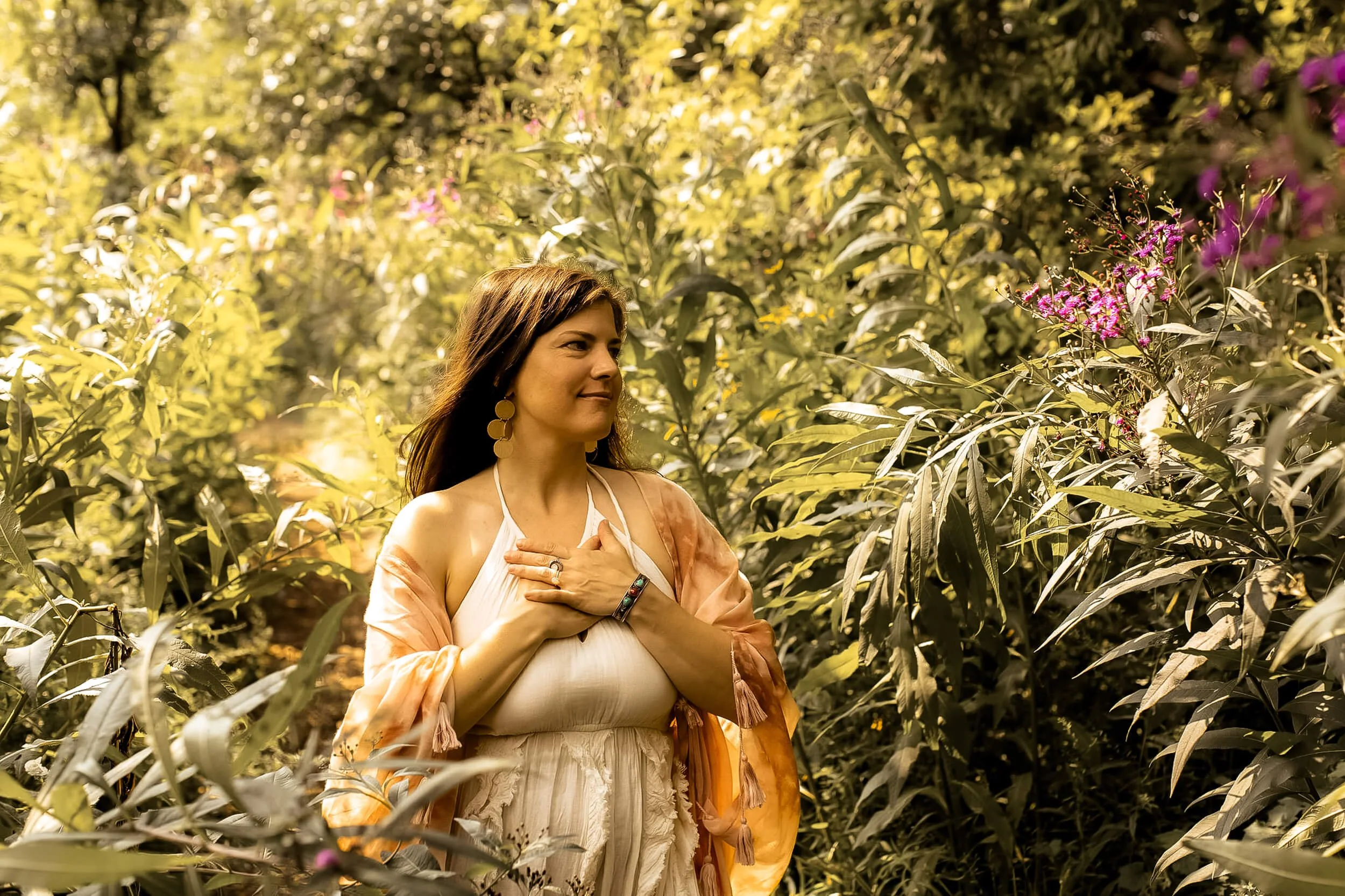 Kristi with hands on heart while surrounded by plants