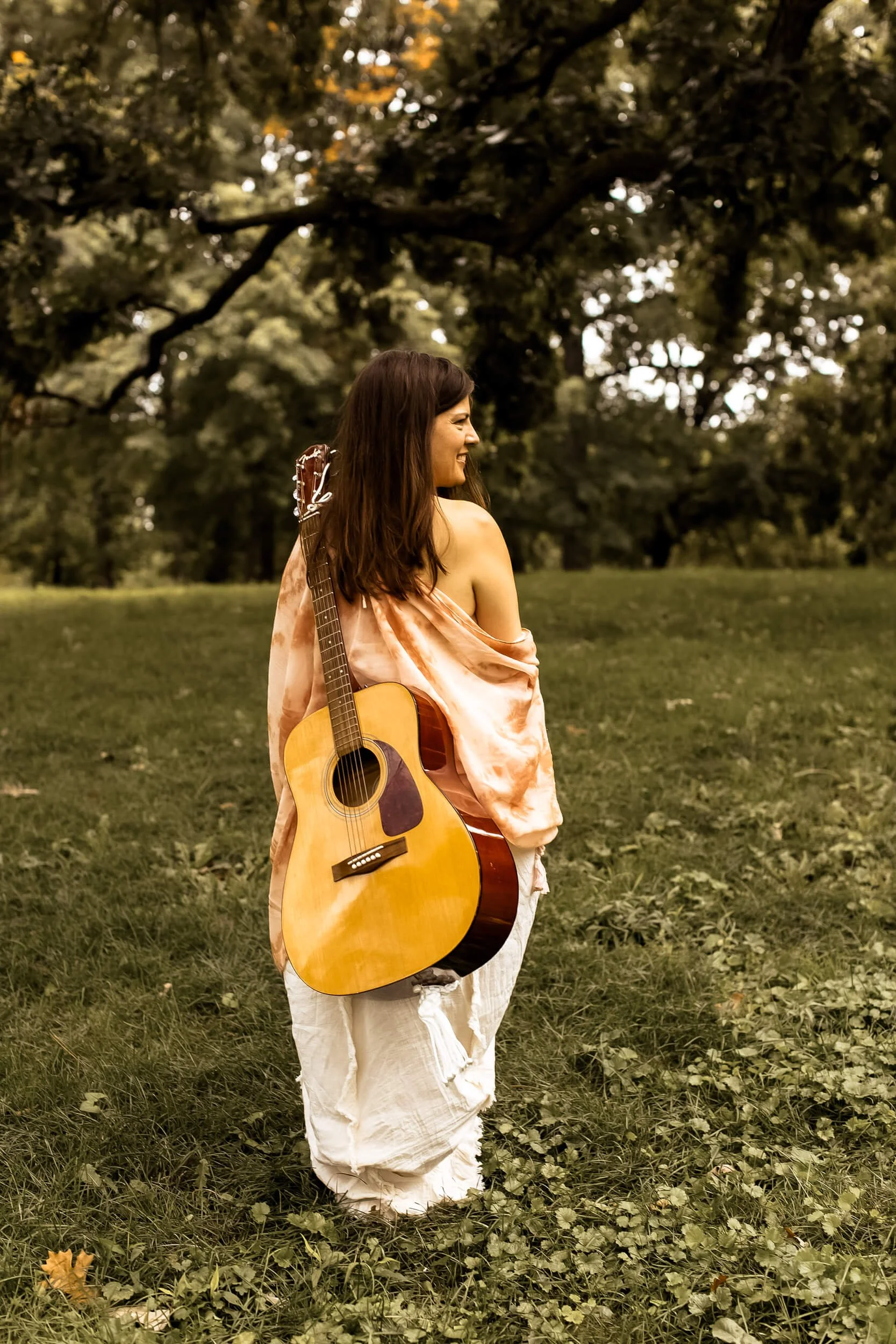 Kristi walking with her guitar but this time she's smiling