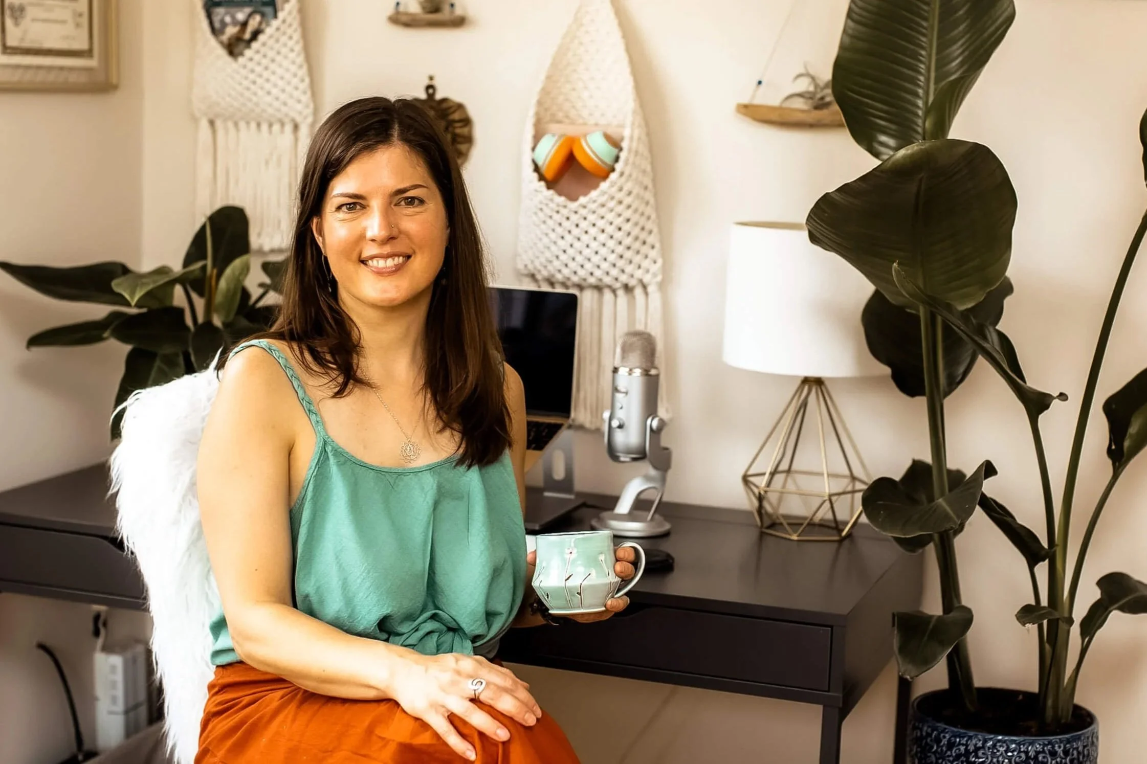 Kristi in her office holding a cup of coffee
