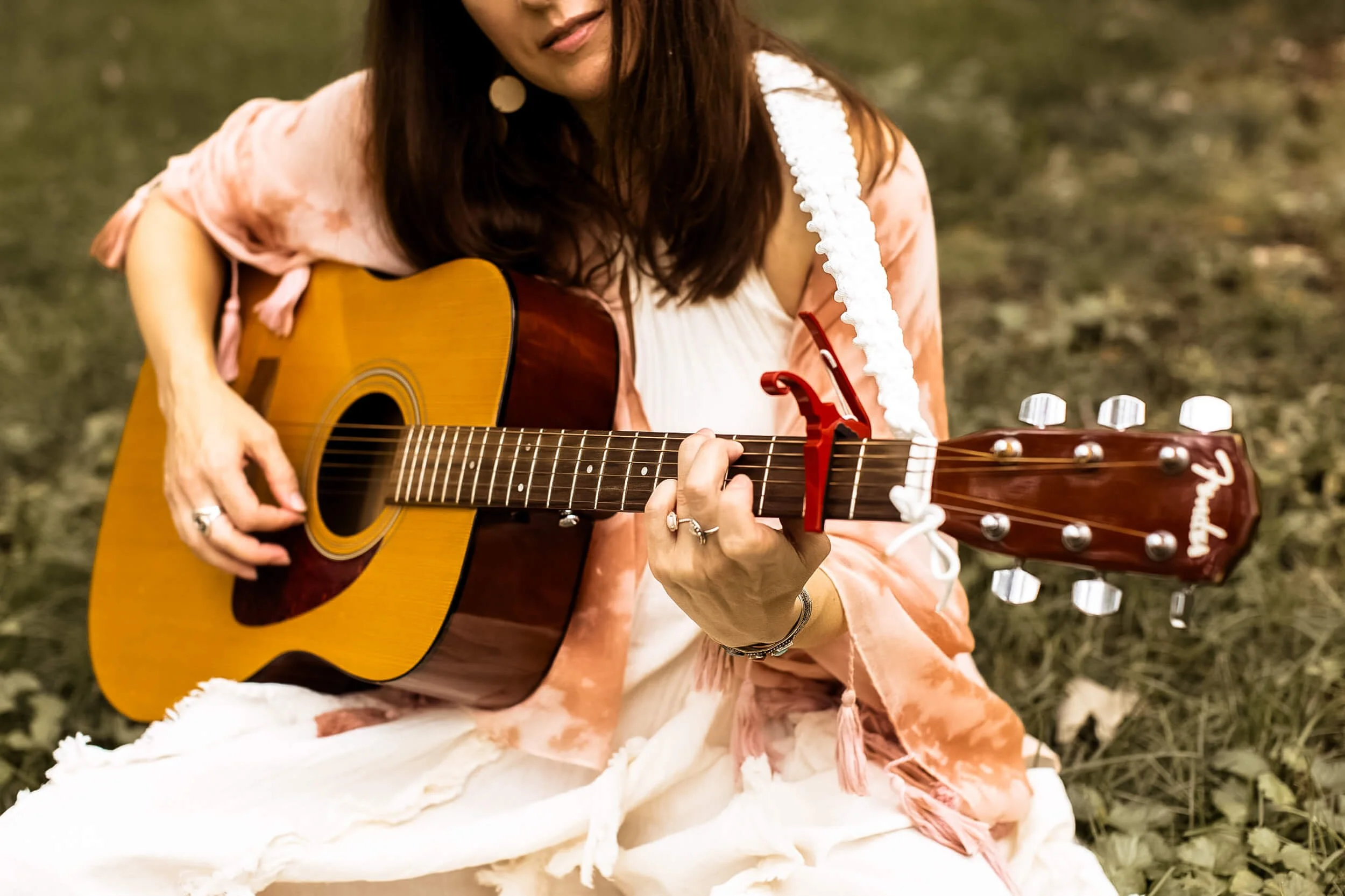 closeup of Kristi playing her guitar