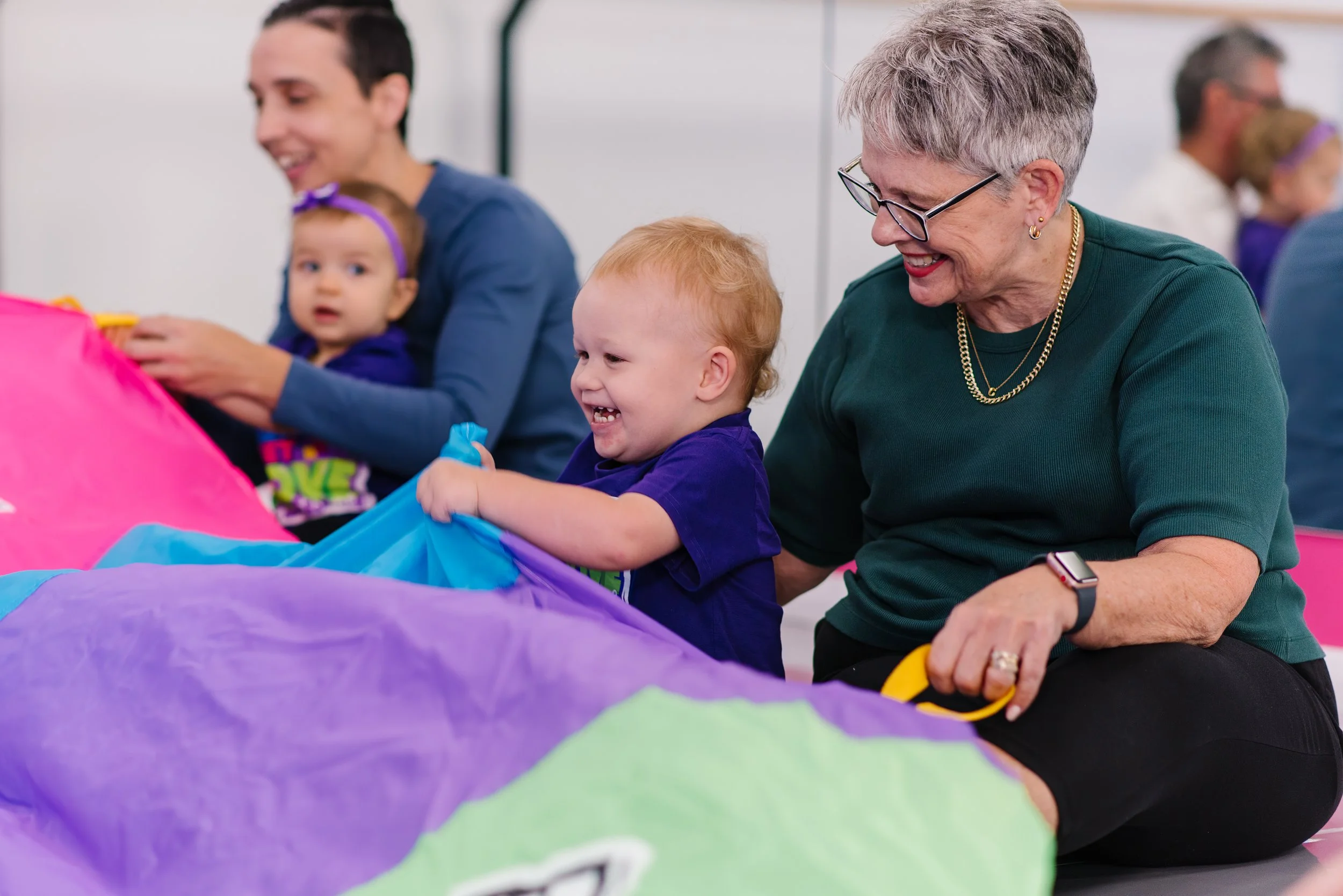 parents and carers in a Ready Set Move class with a parachute