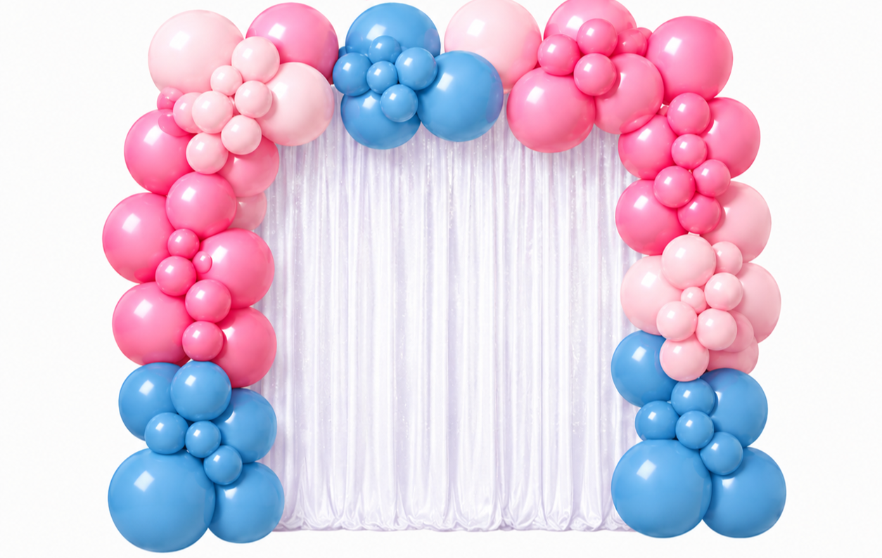 Balloon arch with pink and blue balloons and a white satin curtain backdrop.