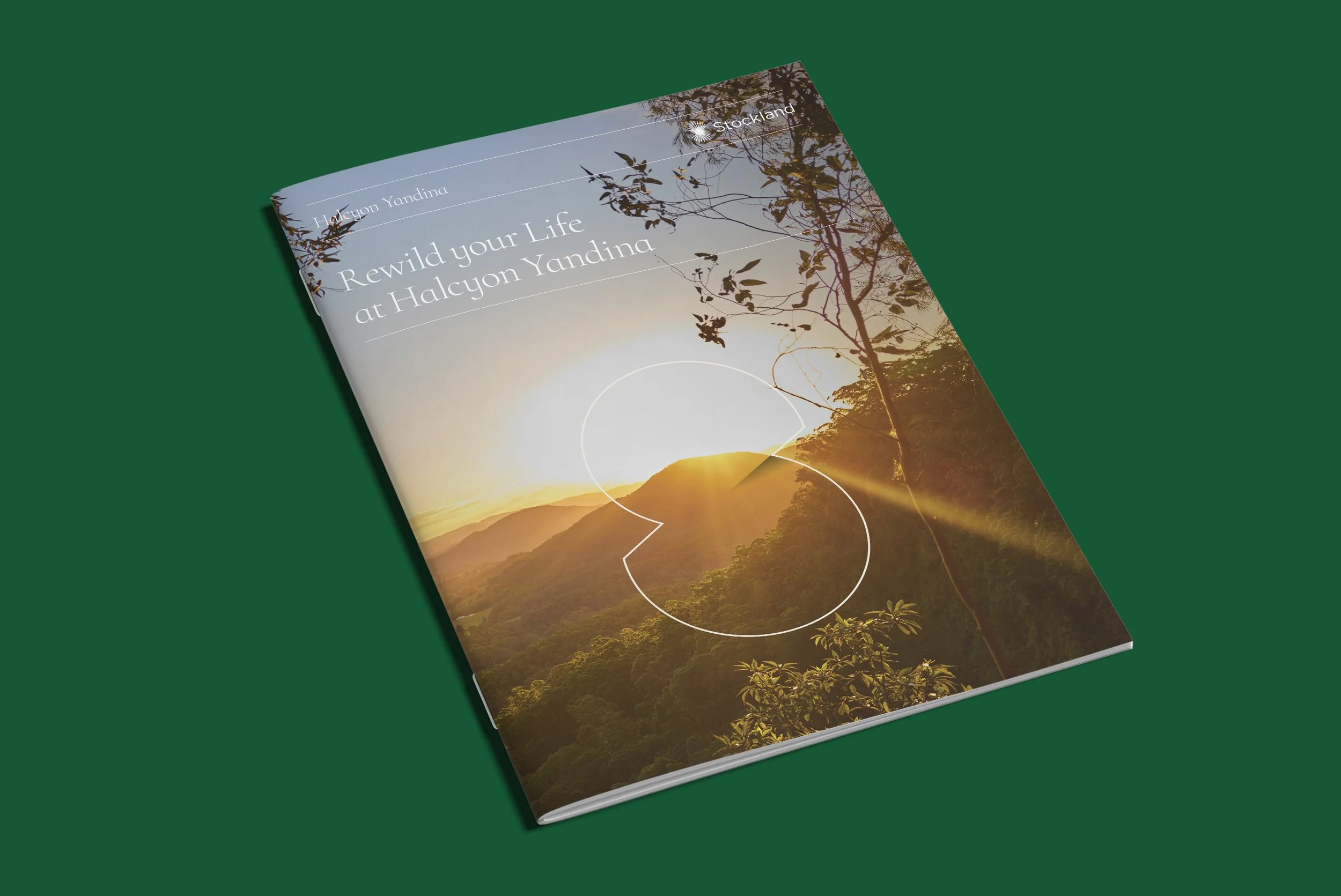 Book titled "Rewild your Life at Halcyon Yandina" with a landscape cover showing a sunrise or sunset over forested mountains and trees.