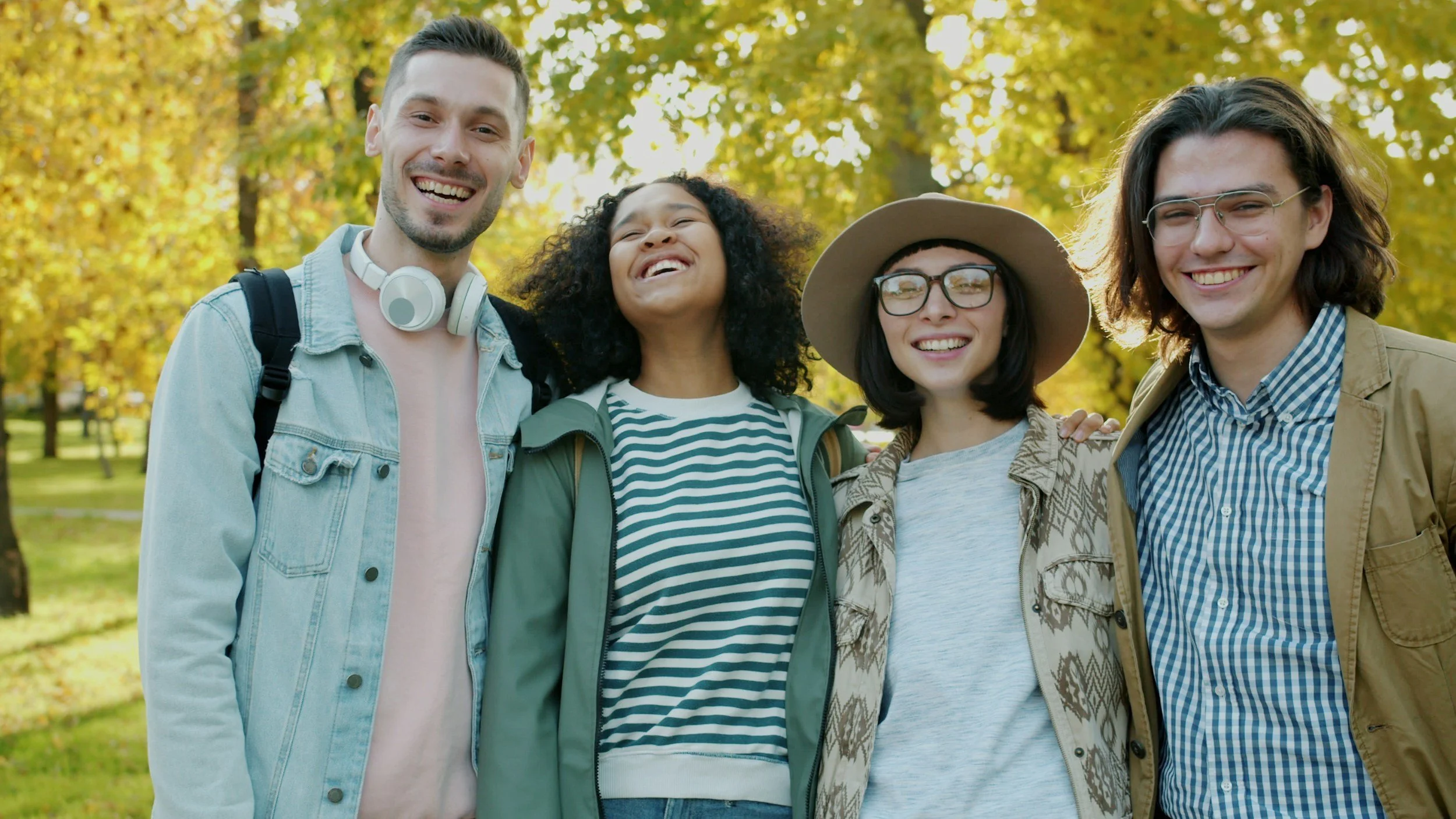 group of diverse young adults smiling and feeling happy with good mental health.