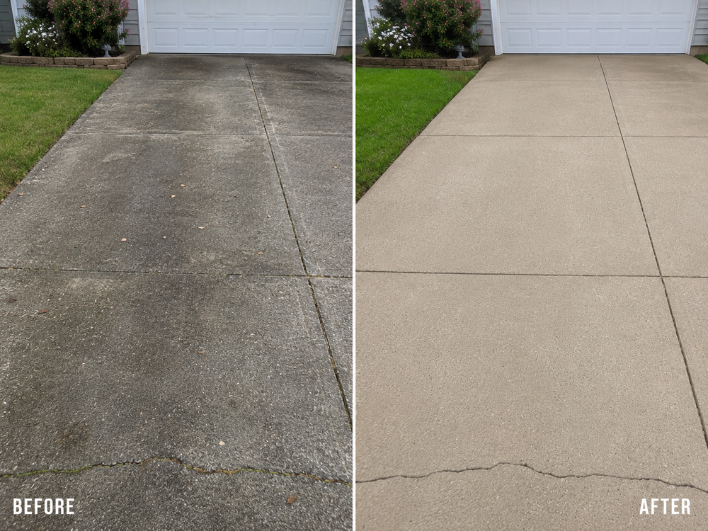 Close-up of a pressure washer wand cleaning a dirty concrete driveway, showing the clean line between washed and unwashed surface