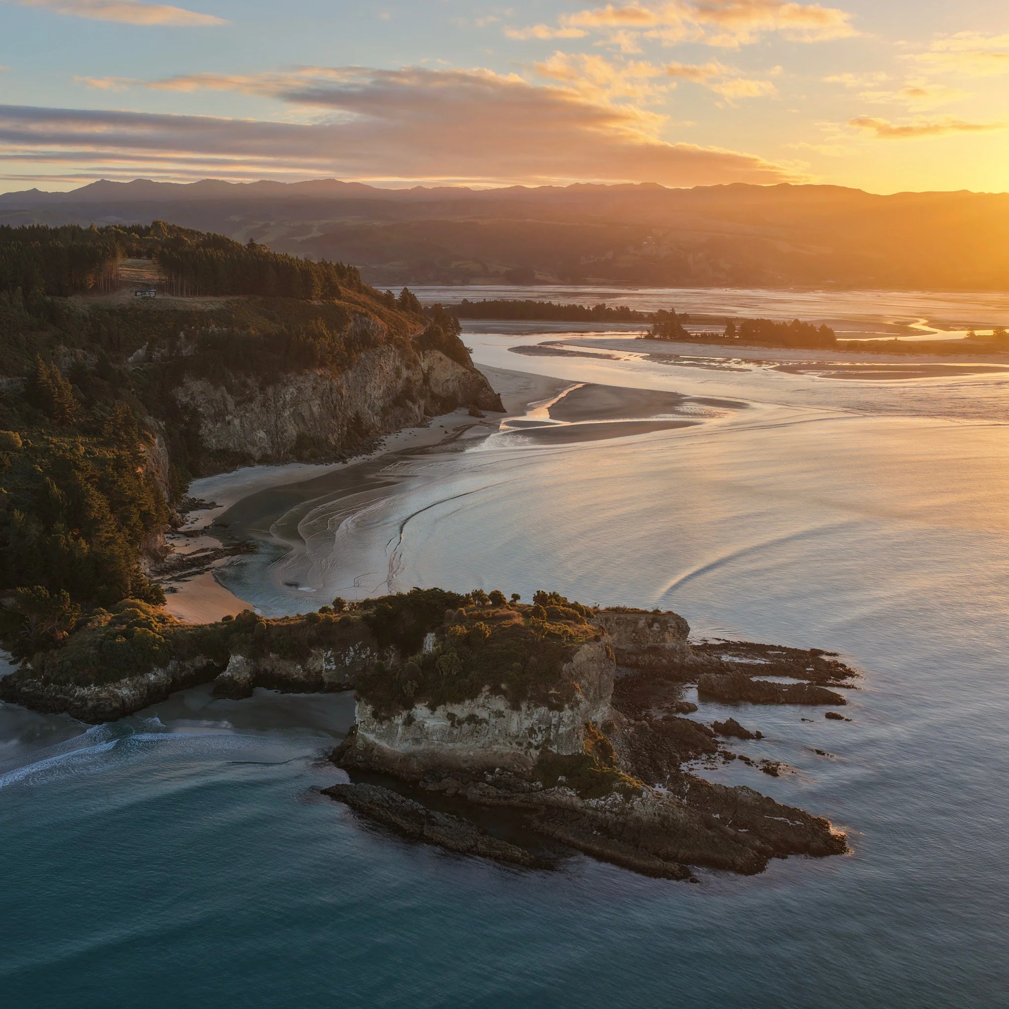 Sunset view of a spectacular coastal headland ver looking the historic Māpoutahi Pā and Canoe Beach.