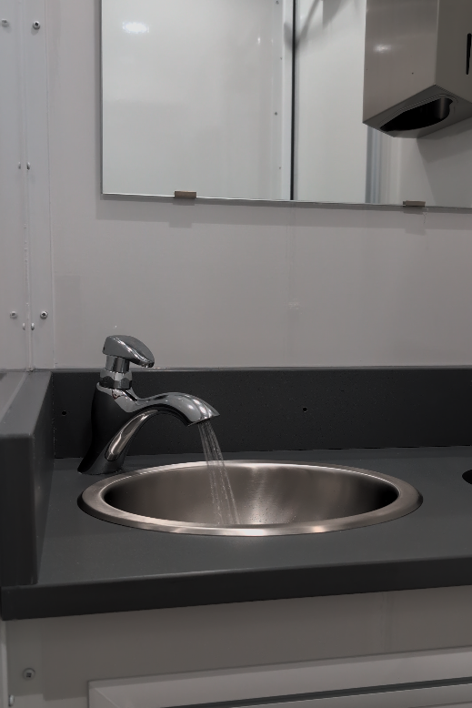 Stainless steel sink and faucet inside a Cordial Elements luxury restroom trailer in Houston, Texas.