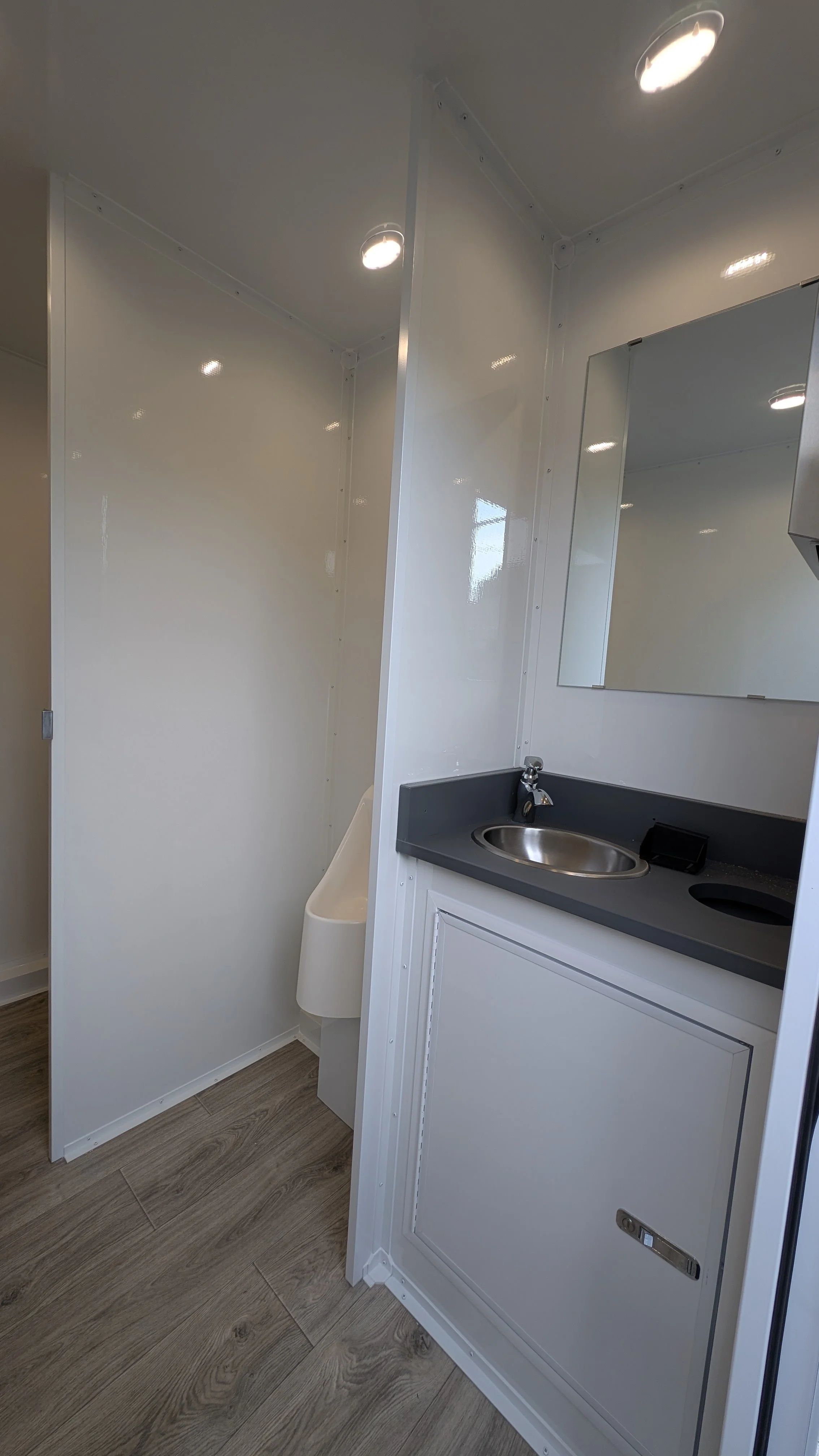 Door shot of vanity, urinal, and stall
