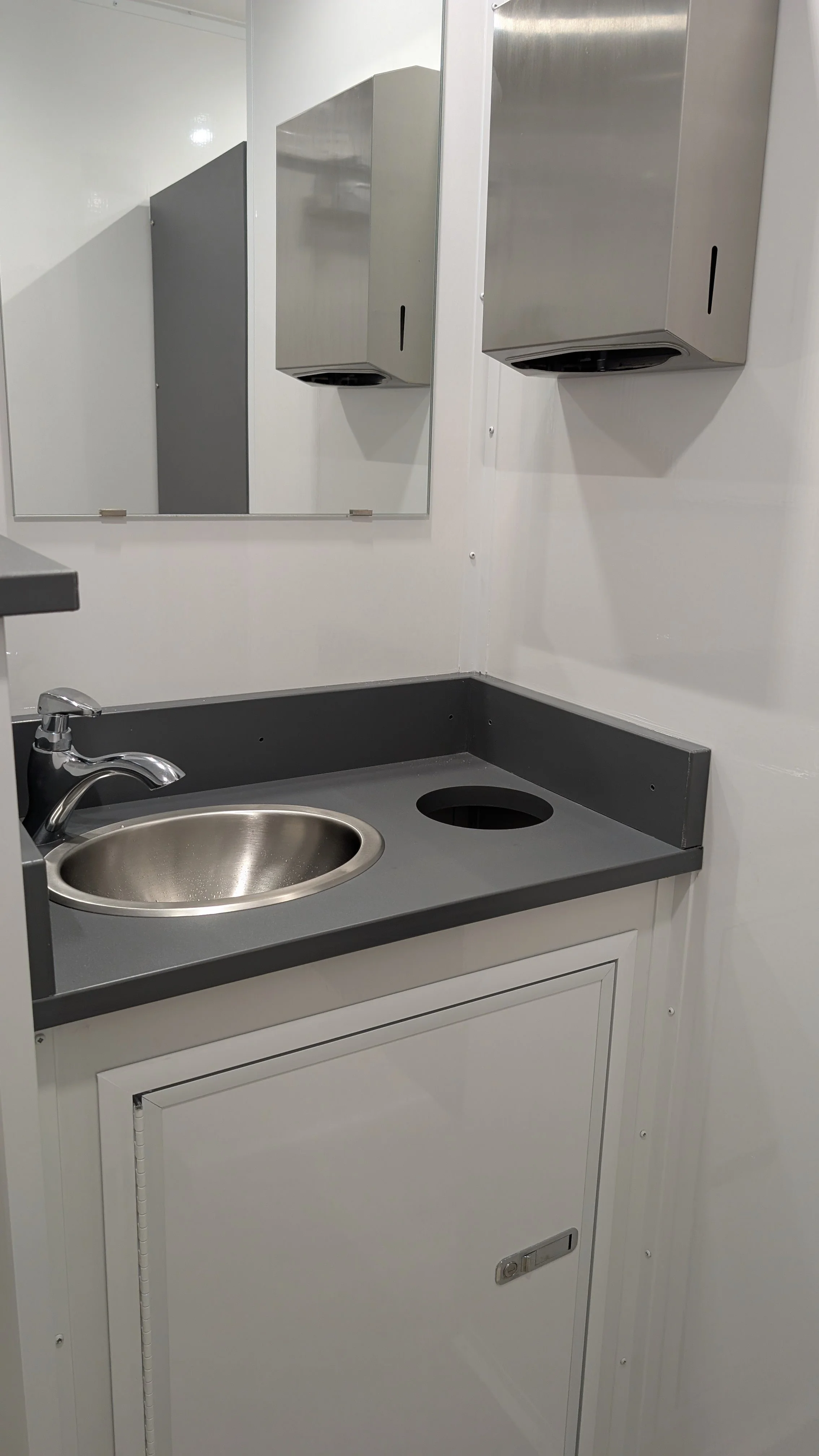 Open vanity with paper towel holder and hidden trash disposal