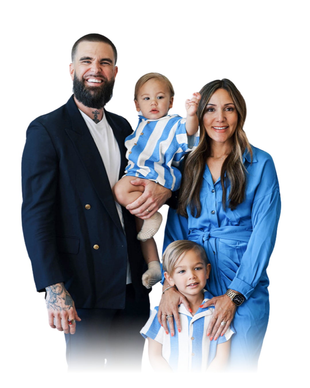 A family portrait of five, including a man with tattoos wearing a dark blazer, a woman in a blue dress, a young boy with blond hair in a blue and white striped shirt, and a toddler girl in a matching striped outfit being held by the man.