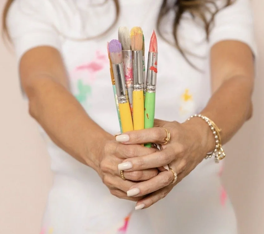 Close-up of hands working with paint and art materials