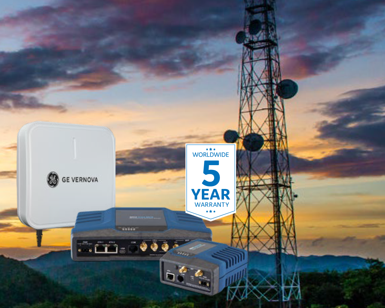A transmission tower with antennas and communication devices, with a sunset sky in the background. In the foreground are networking equipment branded GE Vernova, with a sign indicating a 5-year nationwide warranty.