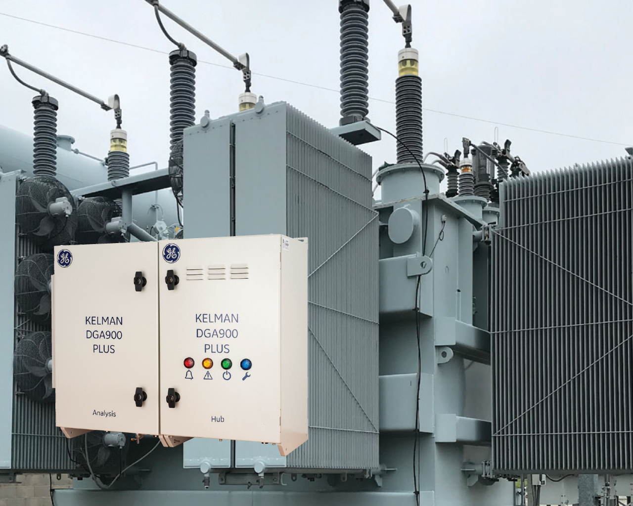 Close-up of electrical transformer equipment including control panels labeled 'Kelman DGA900 Plus' with indicator lights, mounted on a power grid structure.