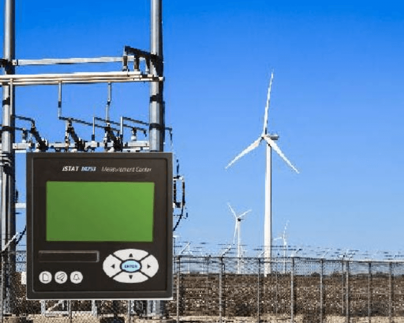 Wind turbines in a wind farm with a measurement instrument in the foreground.