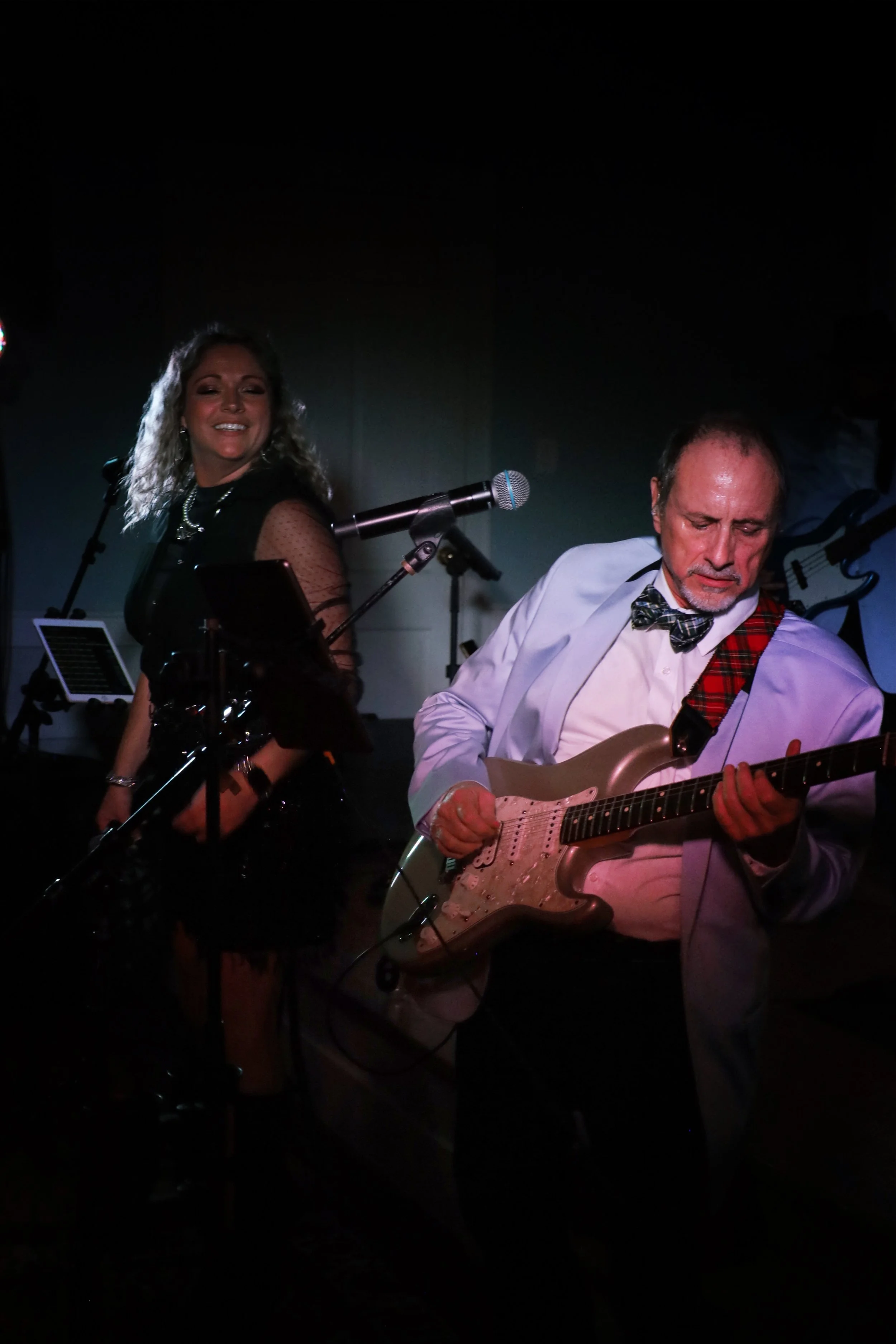 Charles Stewart playing guitar at a wedding, singing next to Danielle Stadick