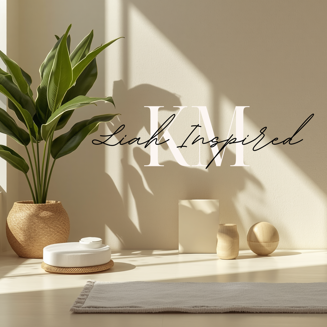 Minimalist decor with a large green plant in a woven basket, abstract wooden and ceramic vases, a rectangular block, a round good, a white round object on a woven mat, a white cloth, and sunlight casting shadows on the wall. Text overlay says 'K M Liah Inspired'.