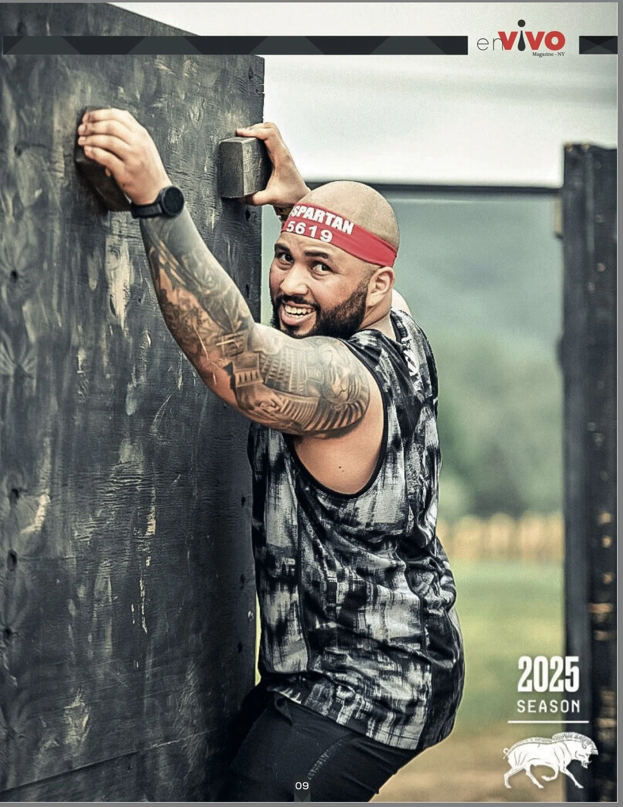 A muscular man with tattoos on his right arm and wearing a red headband labeled 'SPARTAN 5619' is smiling while climbing over a black wooden obstacle during an outdoor obstacle course race. In the background, there are green trees and grass, and the image is marked with '2025 Season' and a rendered logo of a bison.