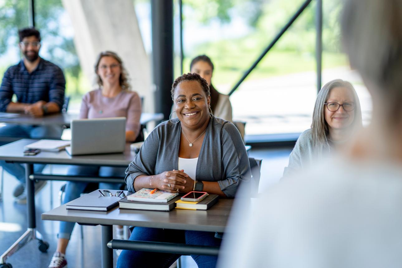 People seated in a classroom listening during a training or presentation.