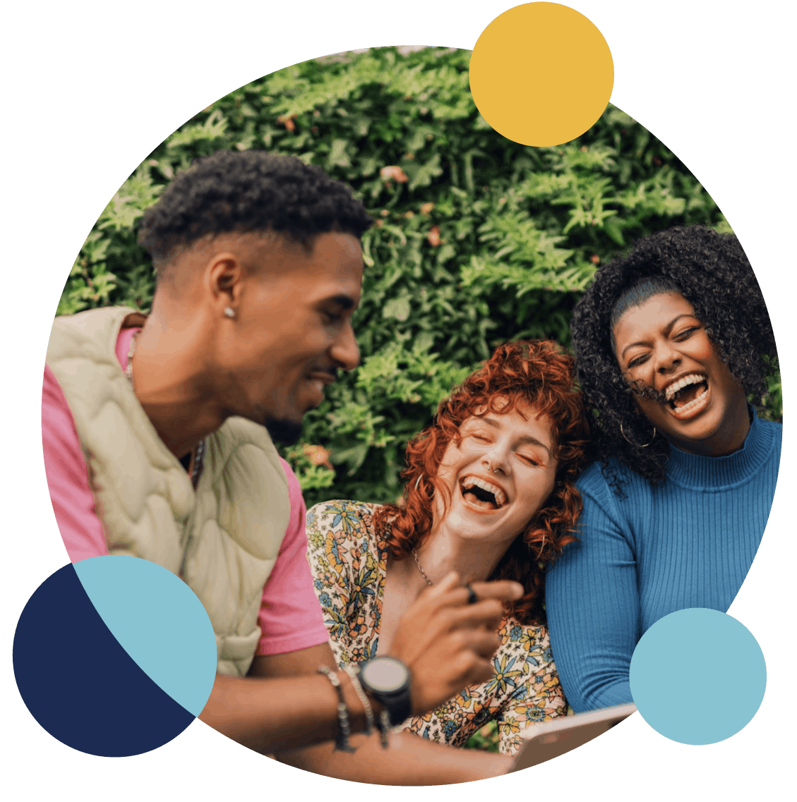 Three friends laughing together outdoors.