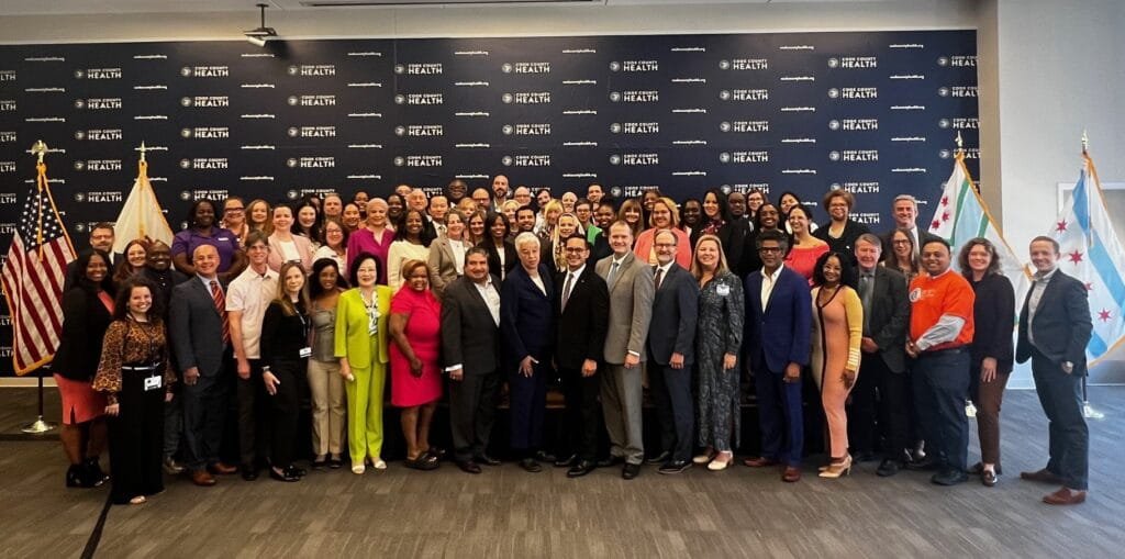 Group photo of Cook County health and community leaders gathered together at an event.