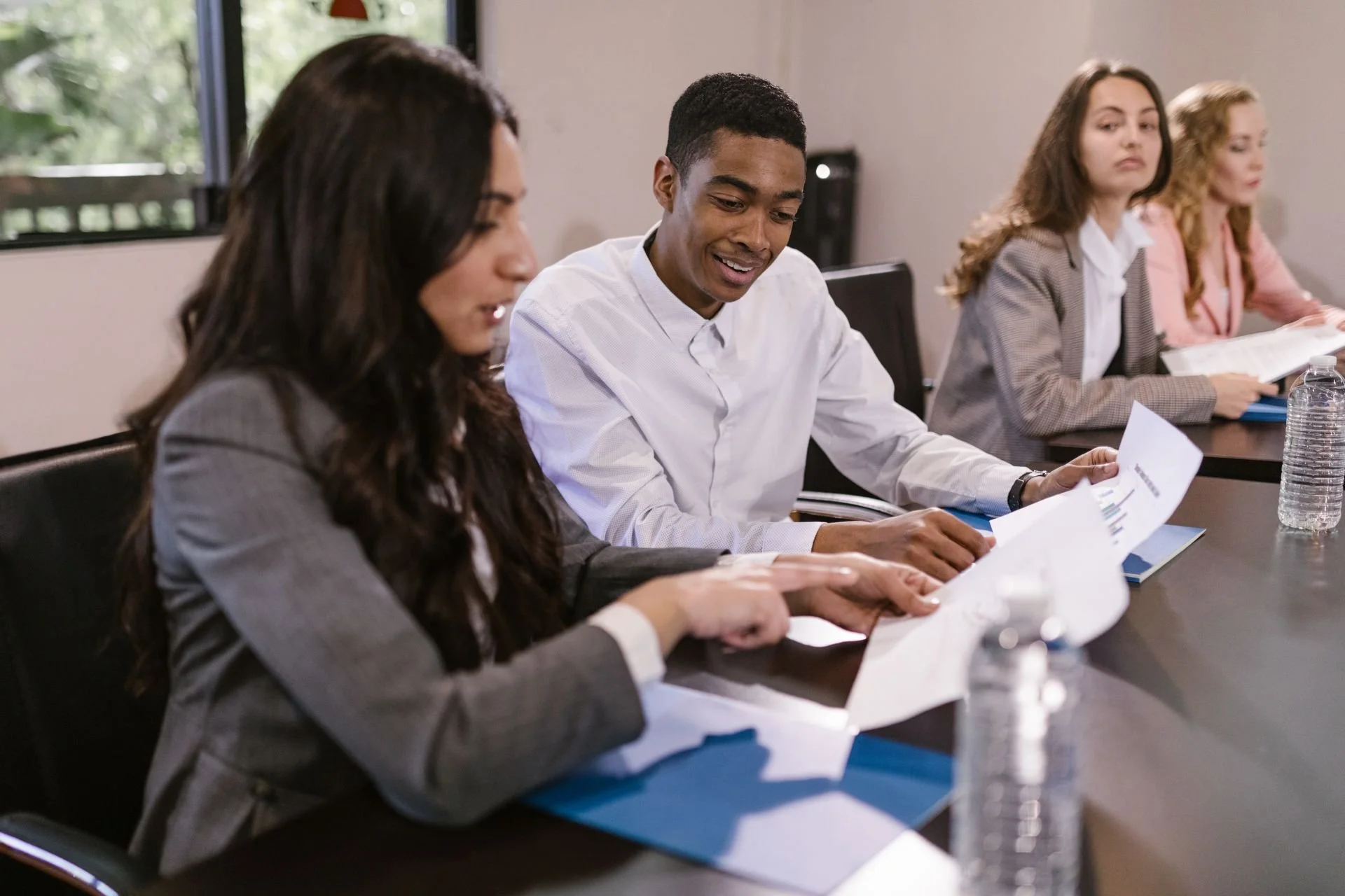 People reviewing documents together during a group meeting.