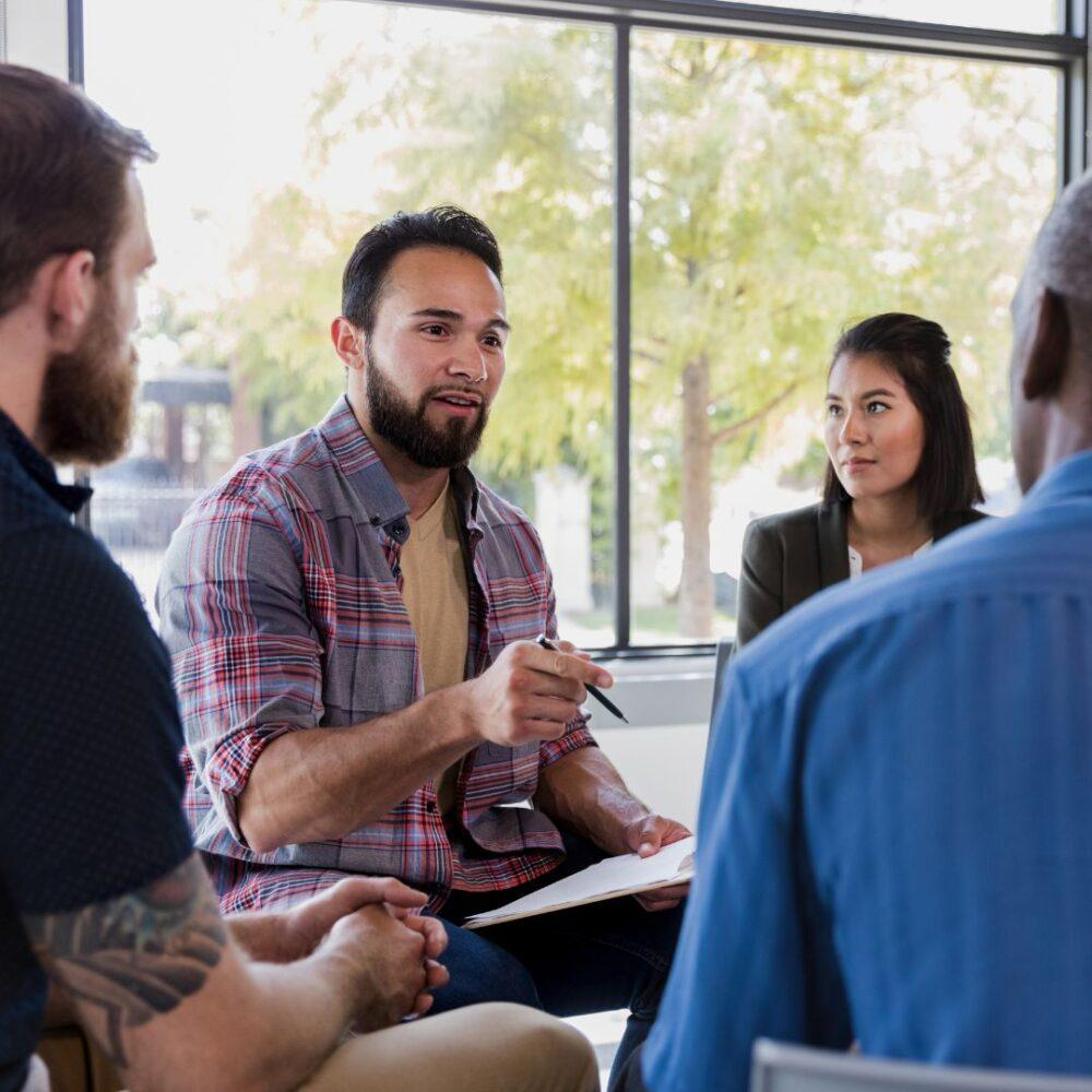 Four people engaged in a small-group discussion.