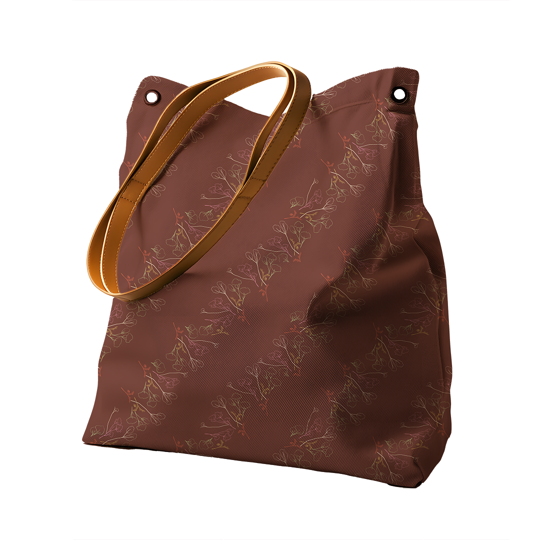 Brown tote bag with a floral gum tree and palm tree pattern with tan handles.
