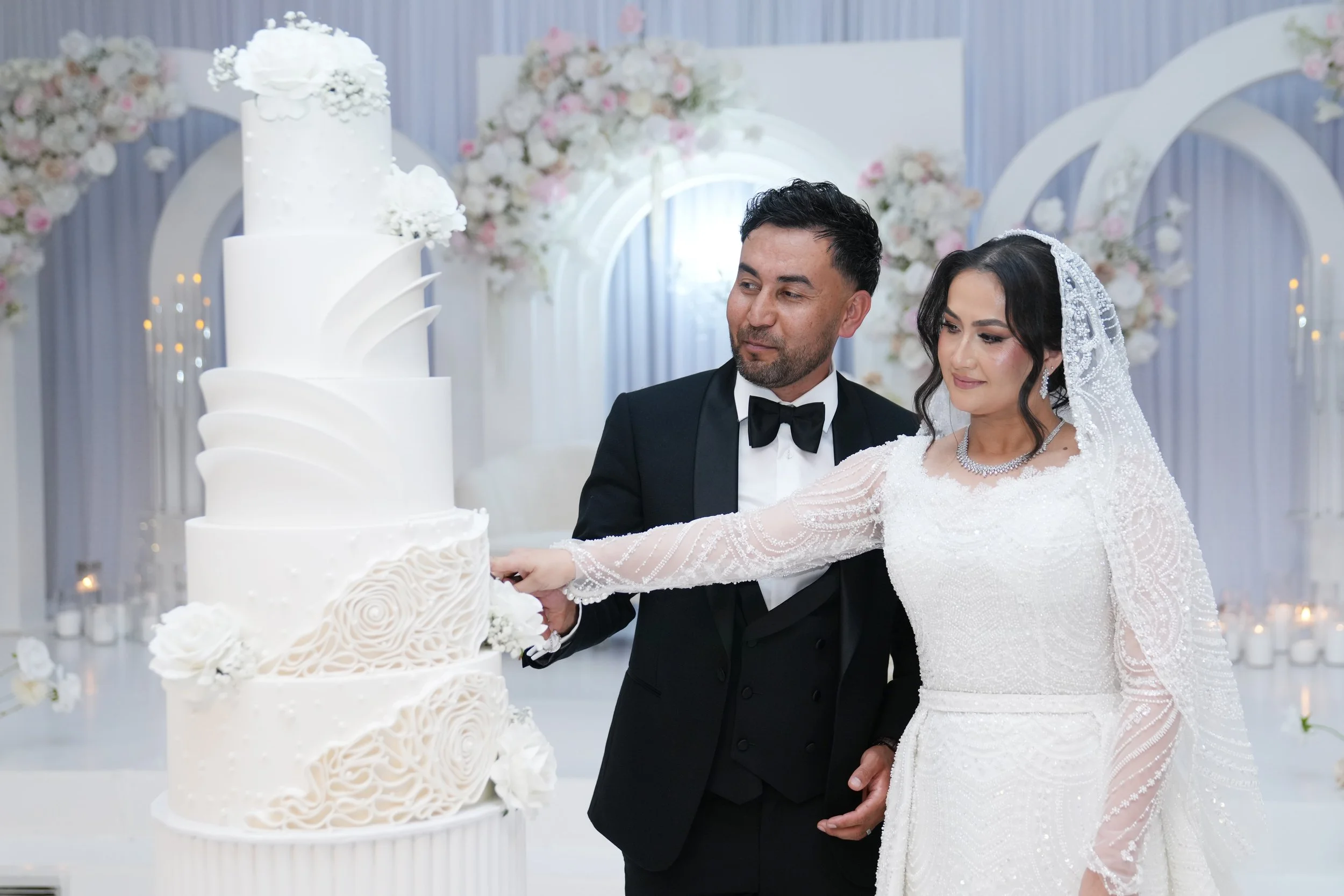 A bride and groom cutting a white wedding cake at Donato the venue in Adelaide