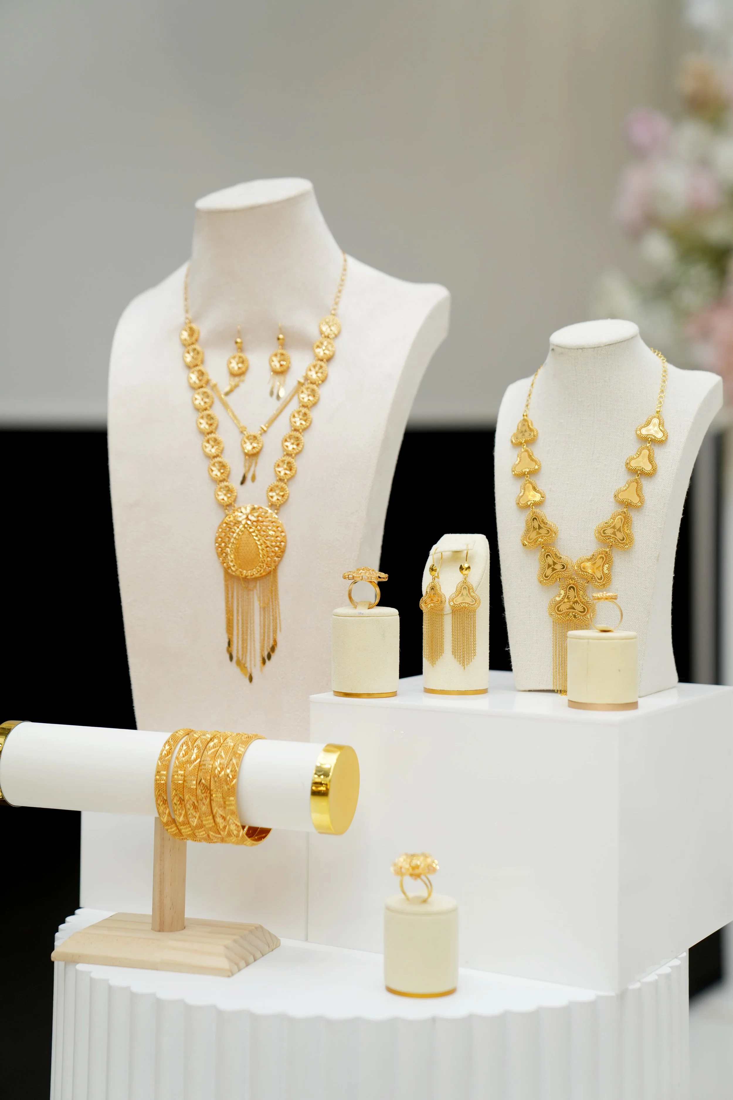 Gold jewelry display with necklaces, earrings, rings, and bracelets on white busts and stands at Donato the venue in Adelaide