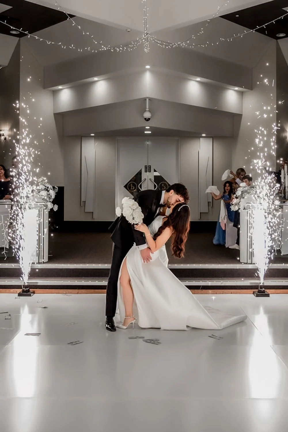 A newlywed couple shares a dance at their wedding reception, with sparklers and celebrations around them at Donato reception centre in Adelaide