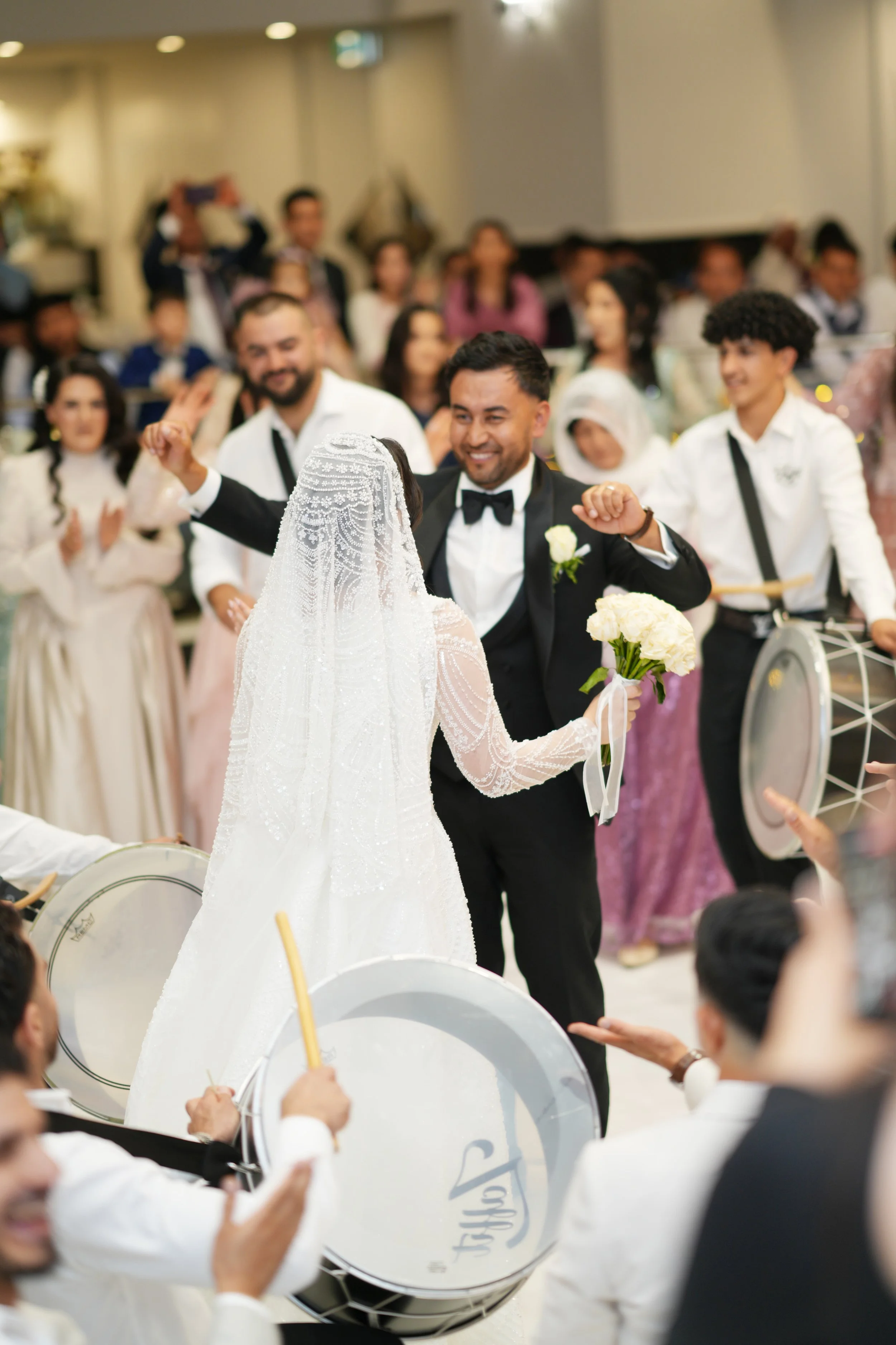 A wedding celebration with a bride and groom dancing while a band plays drums in the foreground, and guests are watching and enjoying the event at Donato the venue in Adelaide