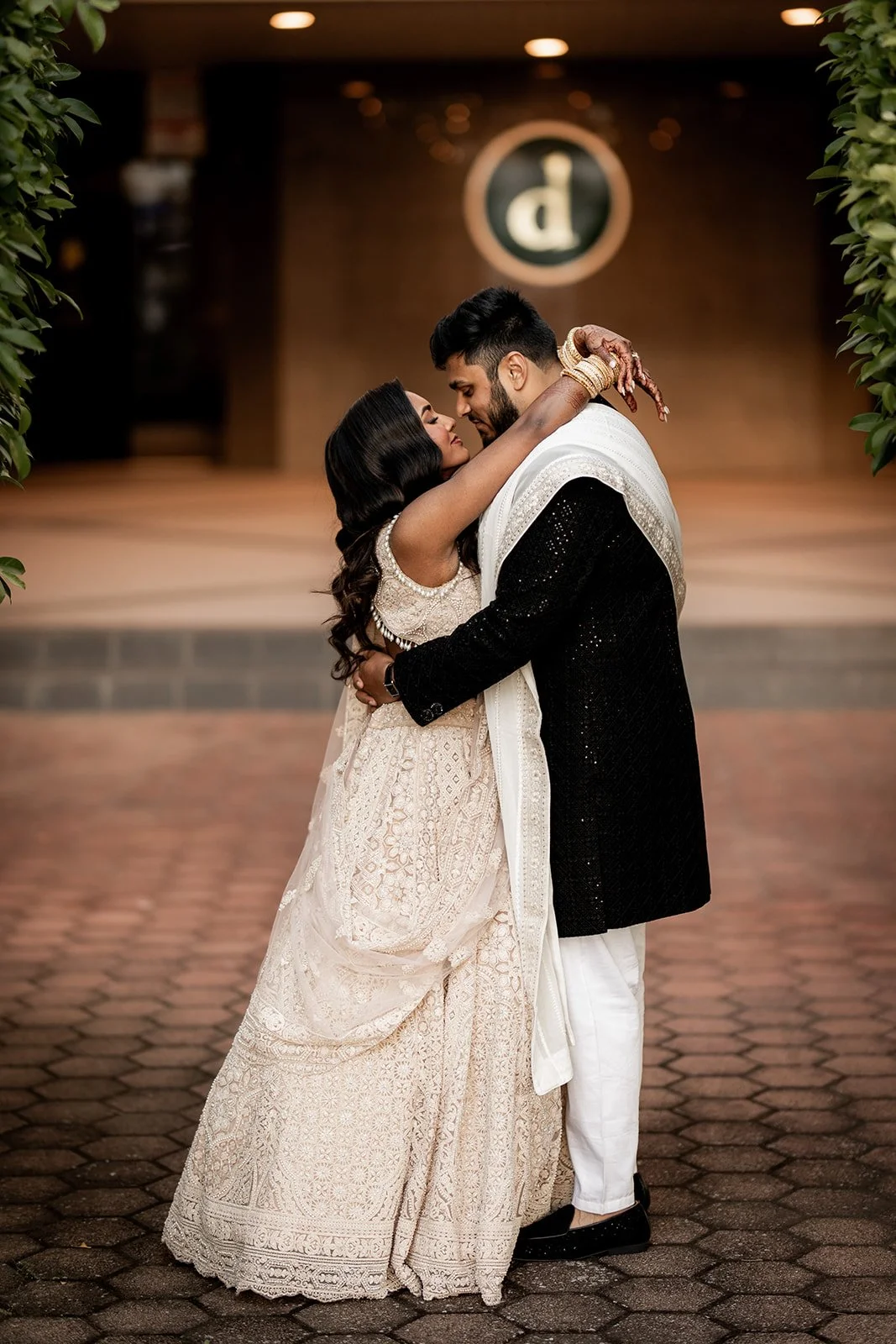 A couple dressed in traditional Indian attire embracing each other in an outdoor setting at night at Donato reception centre in Adelaide