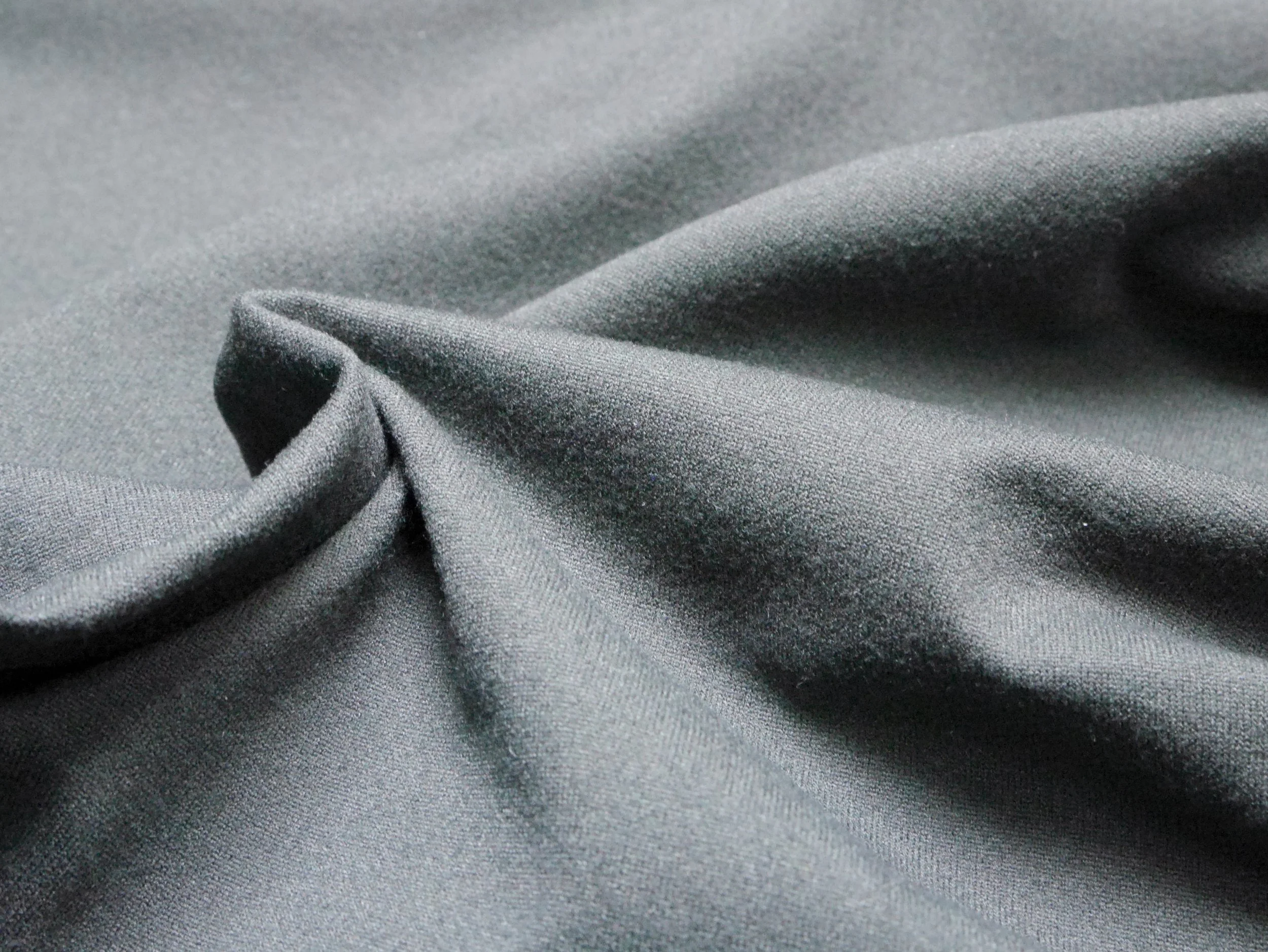 Close-up of smooth, shiny gray fabric with a slight fold.