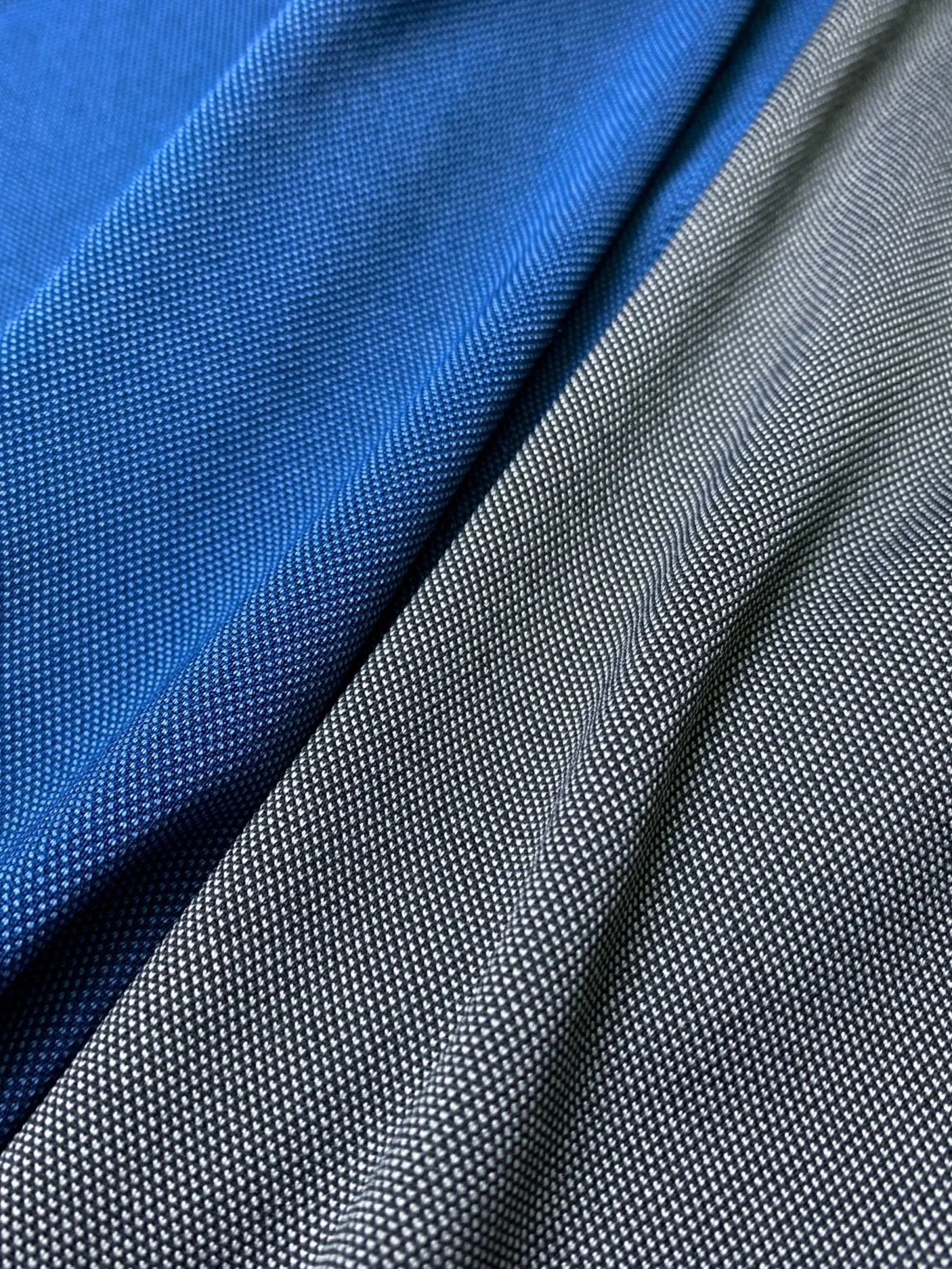 Close-up of folded blue and black patterned fabric with a tiny dot pattern.