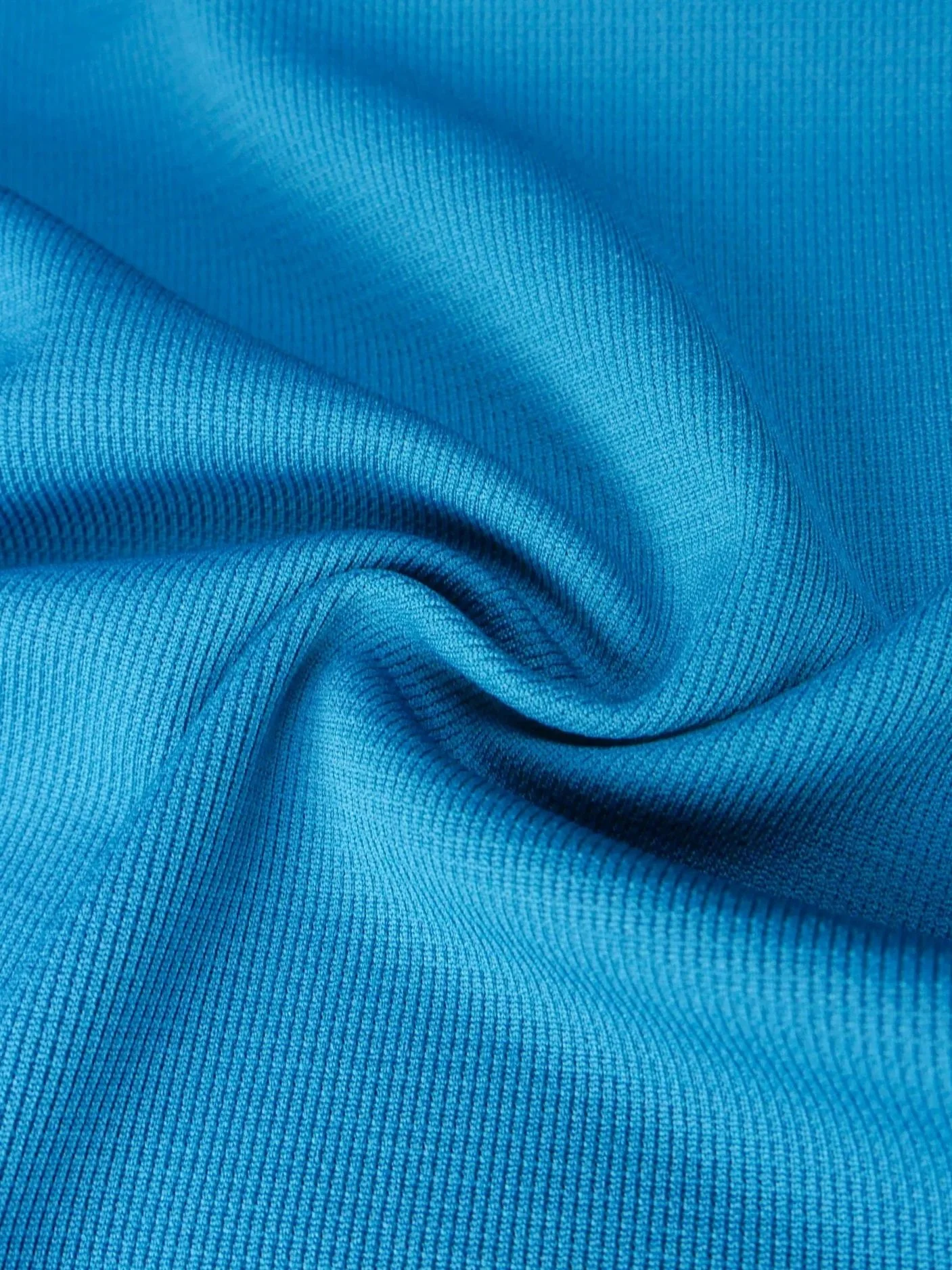 Close-up of a blue, textured fabric with visible threading and soft folds.