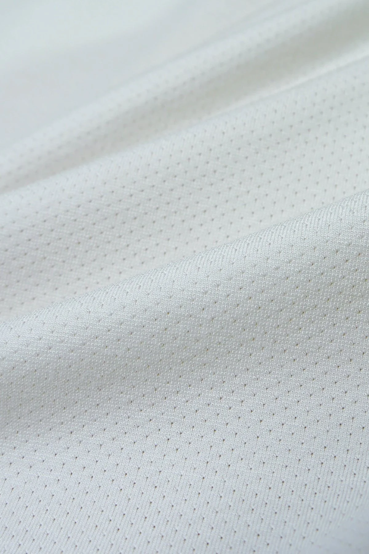 Close-up of white fabric with tiny dotted pattern.