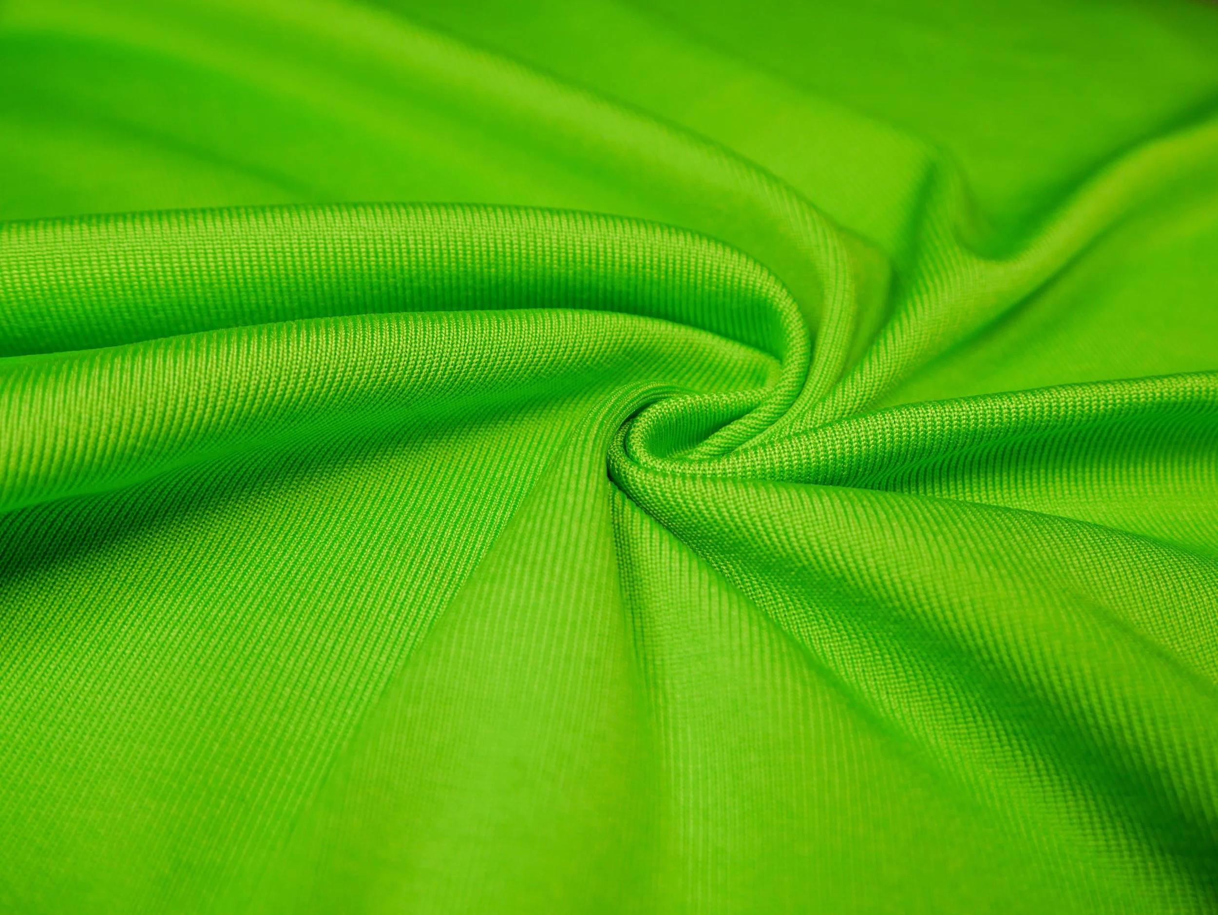DaFon Fabric's close-up image of bright green fabric with detailed texture and folds.