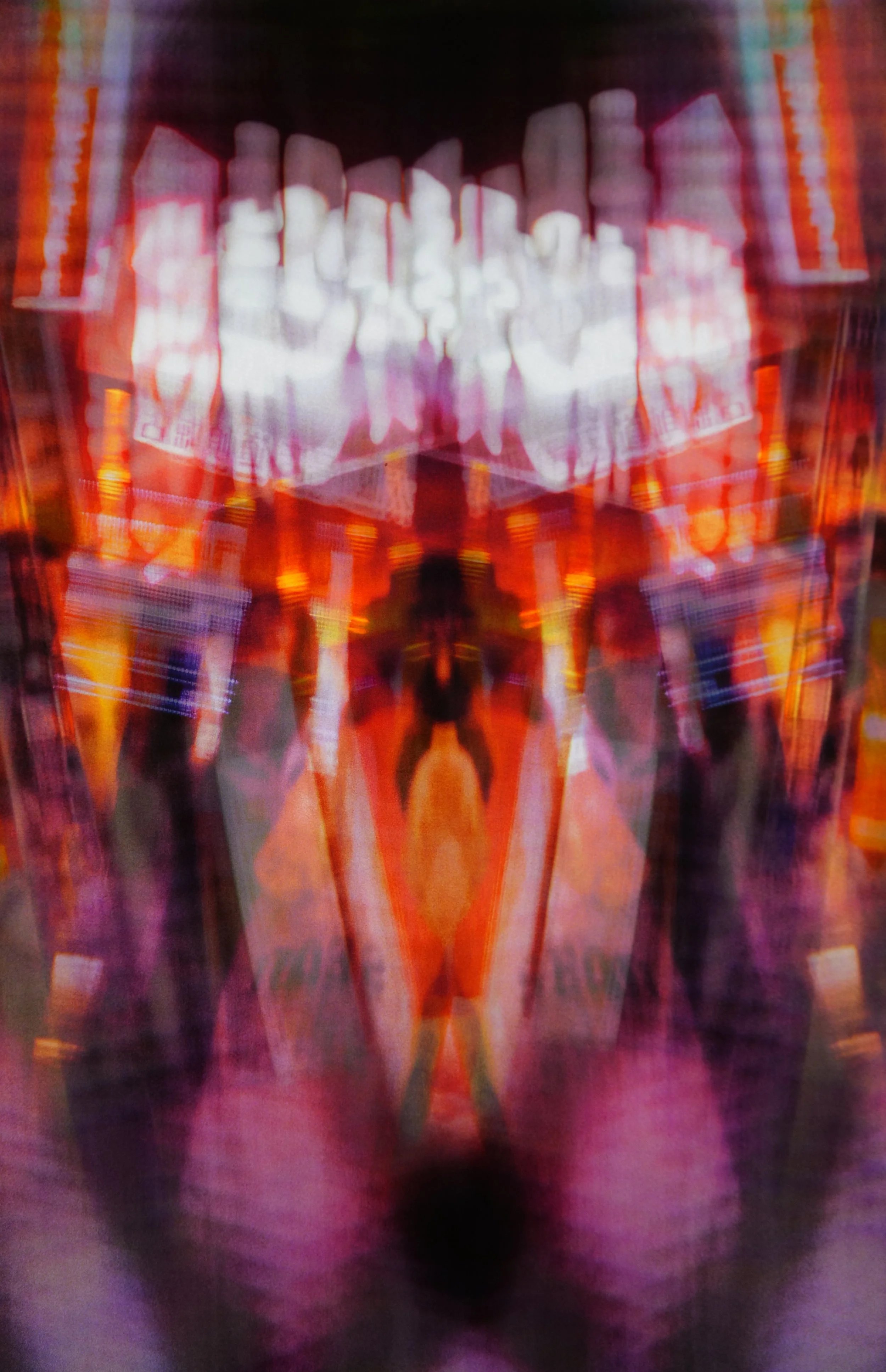 Facade Glyphs

This image feels like a city mask. Two photographs of an entertainment frontage – signs, screens, glowing columns of colour – are laid on top of each other in reverse so that the reflection folds in on itself. On the light box the cent