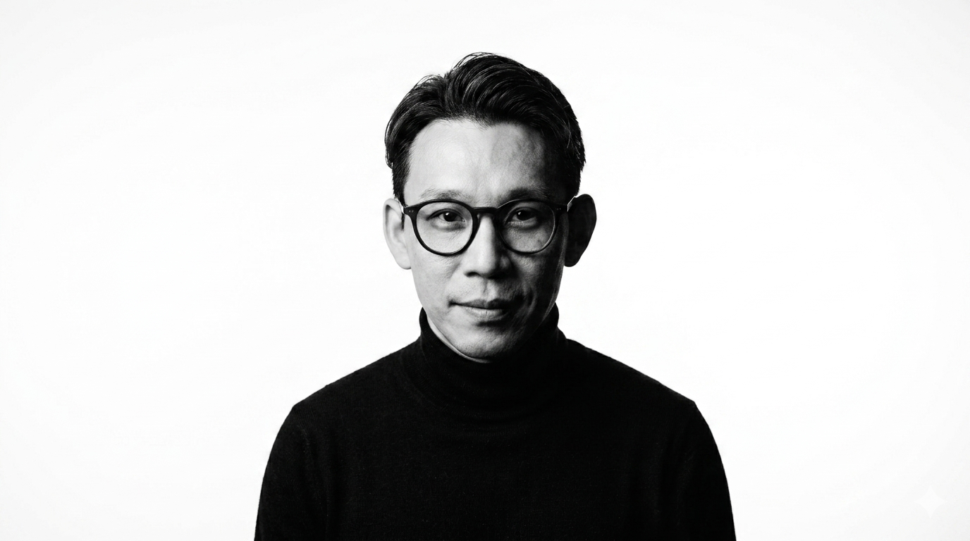 Black and white portrait of a man wearing glasses and a dark turtleneck, looking at the camera against a plain light background.
Street Photographer, Hello from Goto