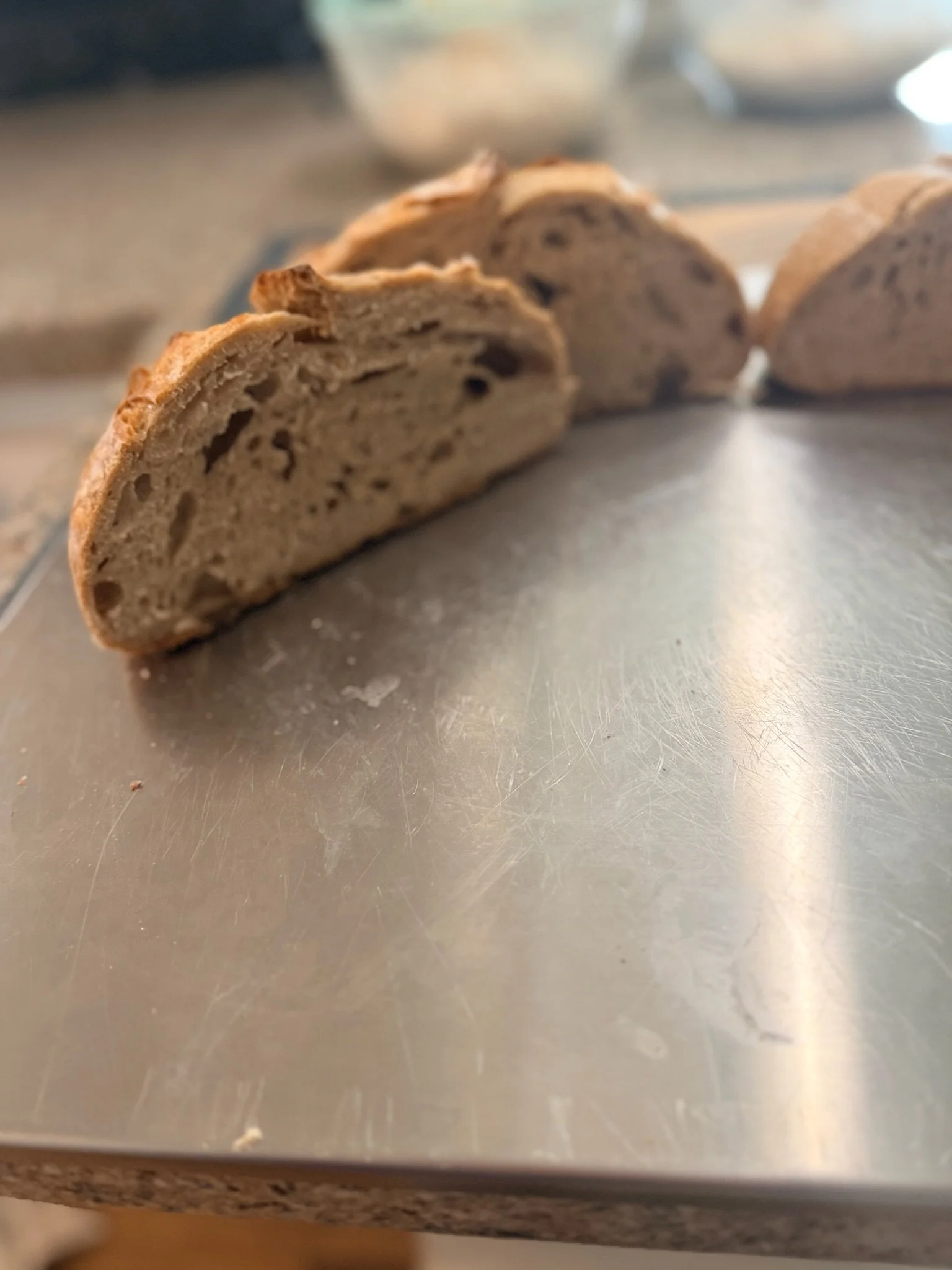 Slices of chocolate chip cookie on a metal surface.
