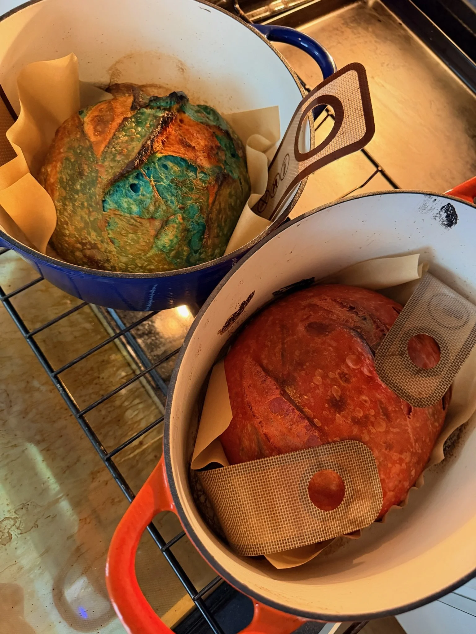 Freshly baked pumpkin bread in a baking pot with parchment paper, resting on a stovetop.